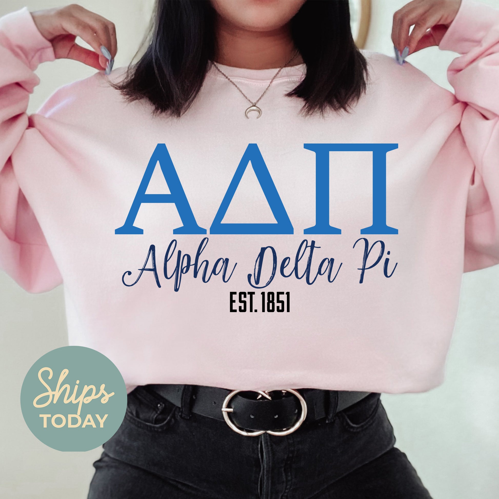 a woman wearing a pink sweatshirt with the letters aati on it