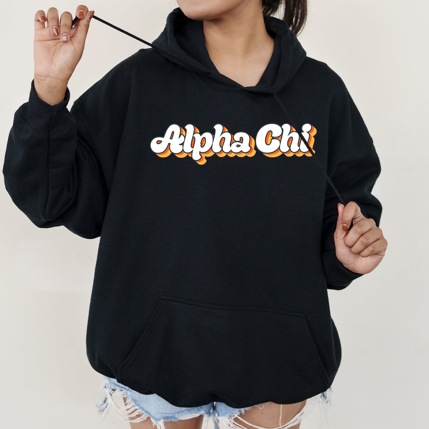 a woman wearing a black hoodie with the word alphabet chi on it