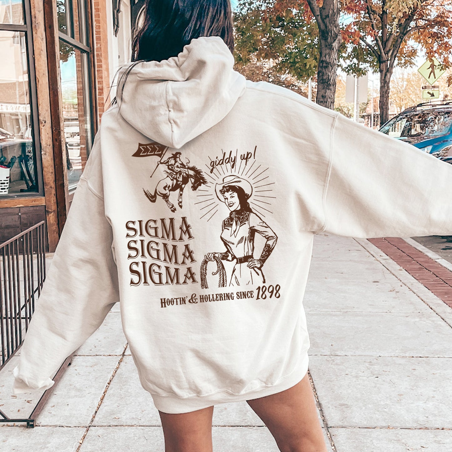 a woman in a white hoodie is walking down the street