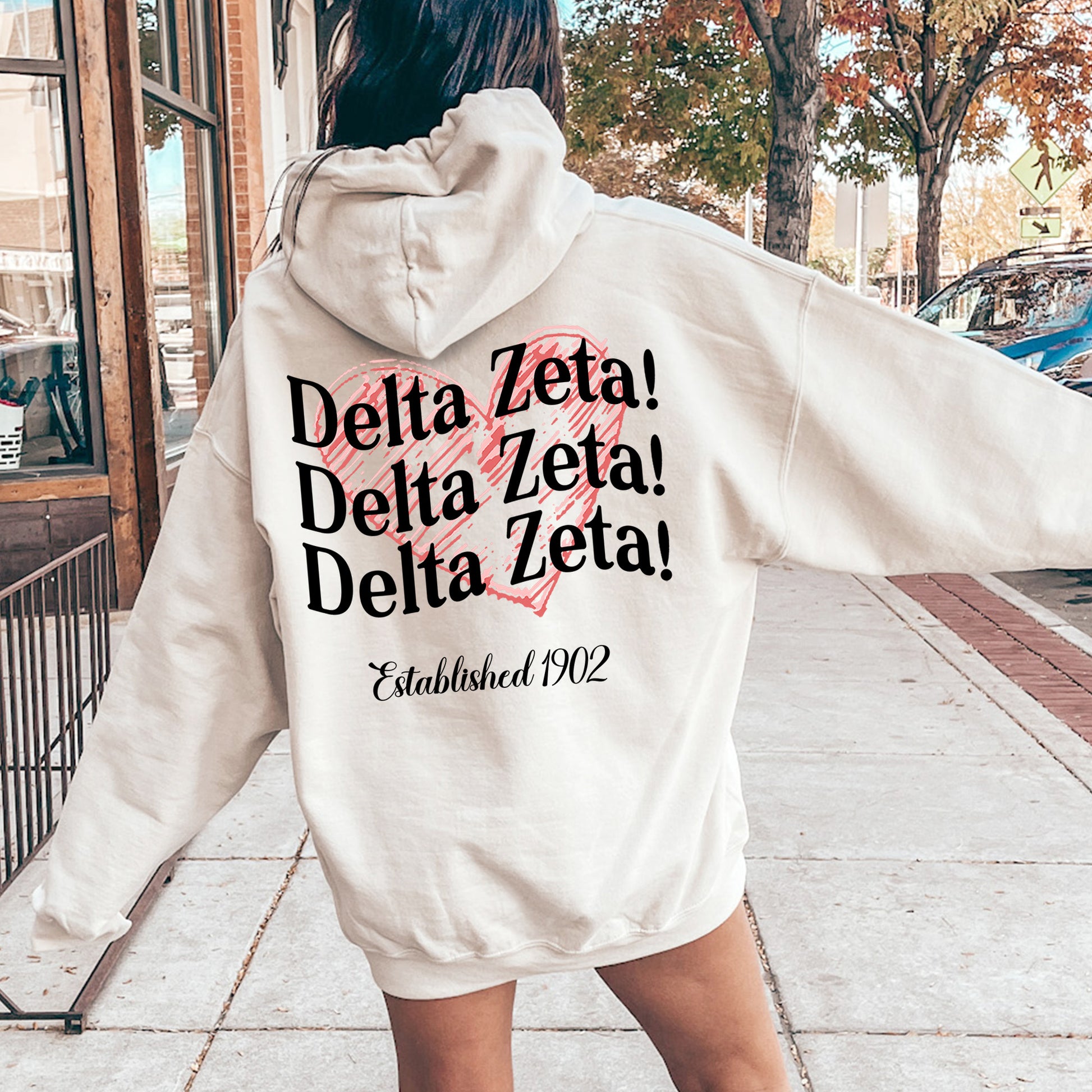 a woman in a white hoodie is walking down the street