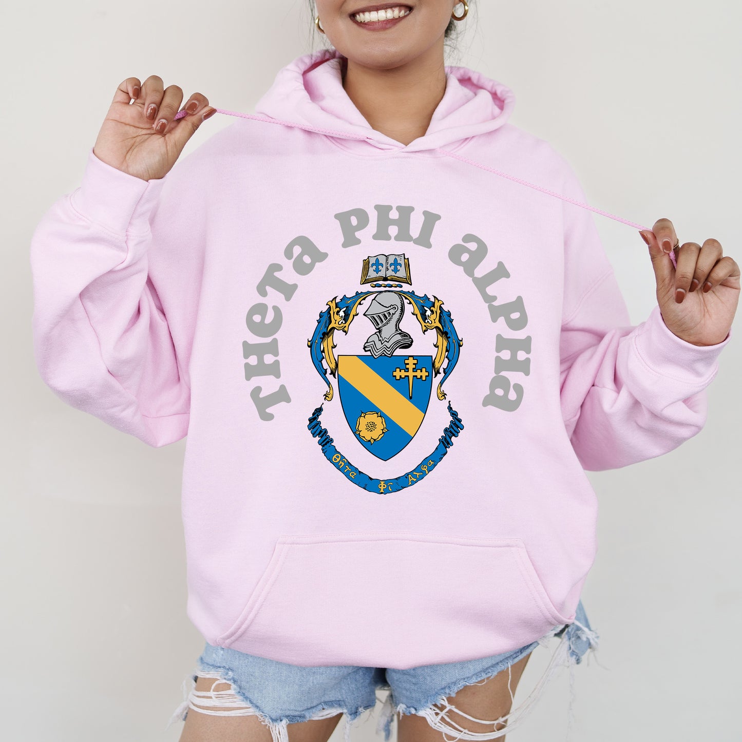 a woman wearing a pink phi phi hoodie