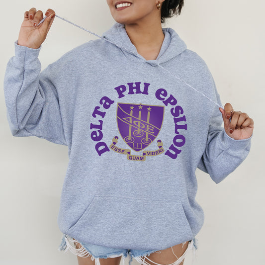 a woman in a blue hoodie holding a toothbrush