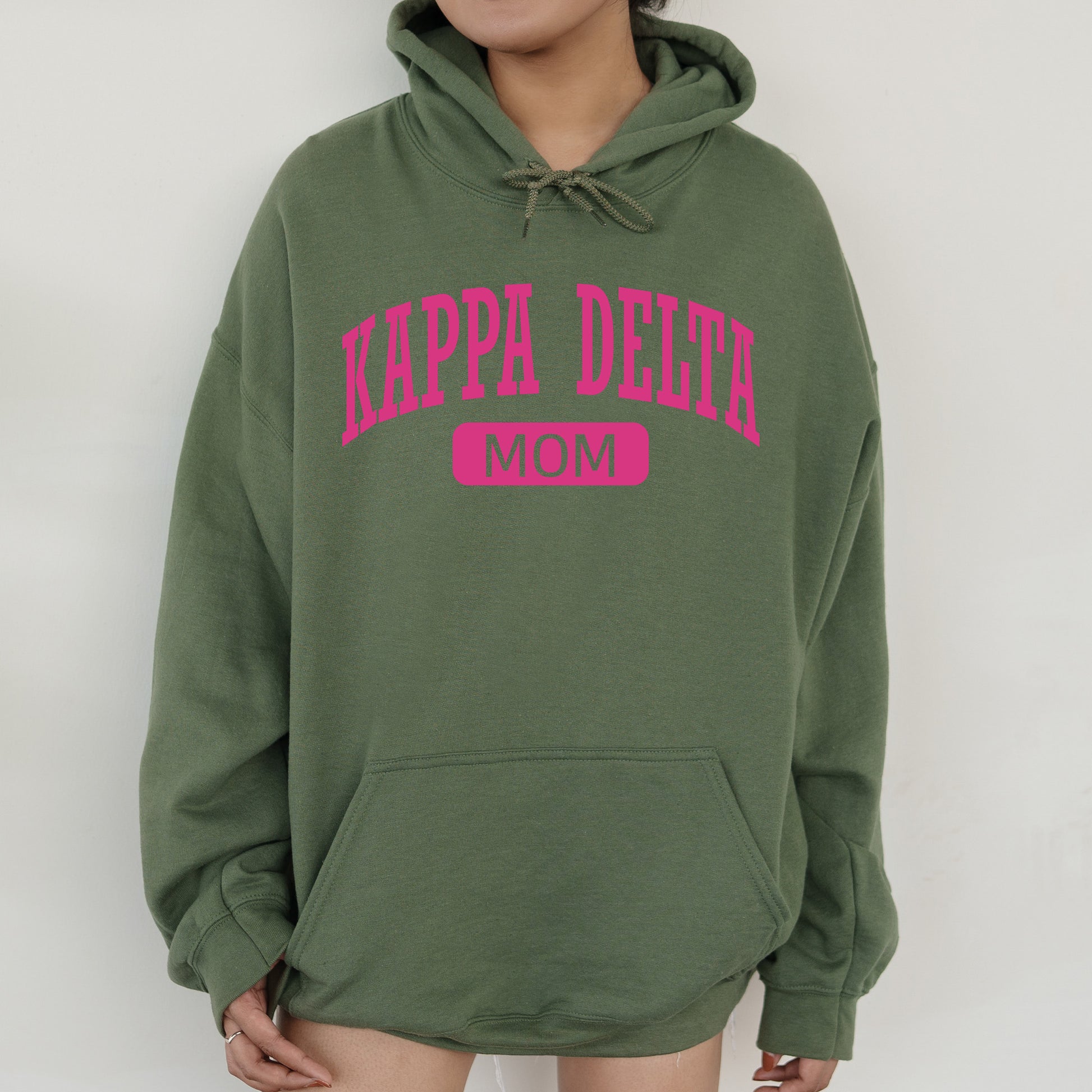 a woman wearing a green hoodie with pink letters on it