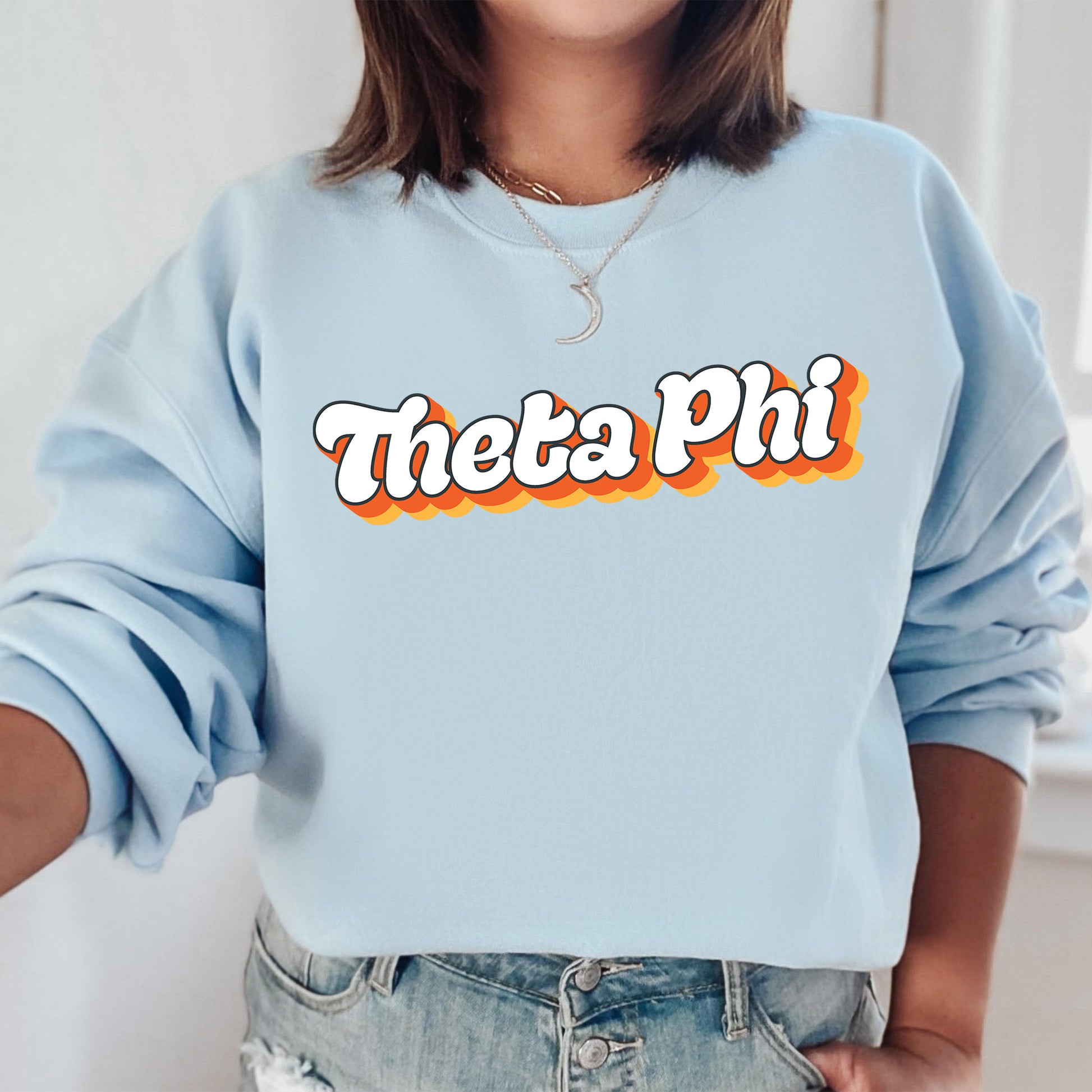 a woman wearing a blue sweatshirt with the word thea pi on it