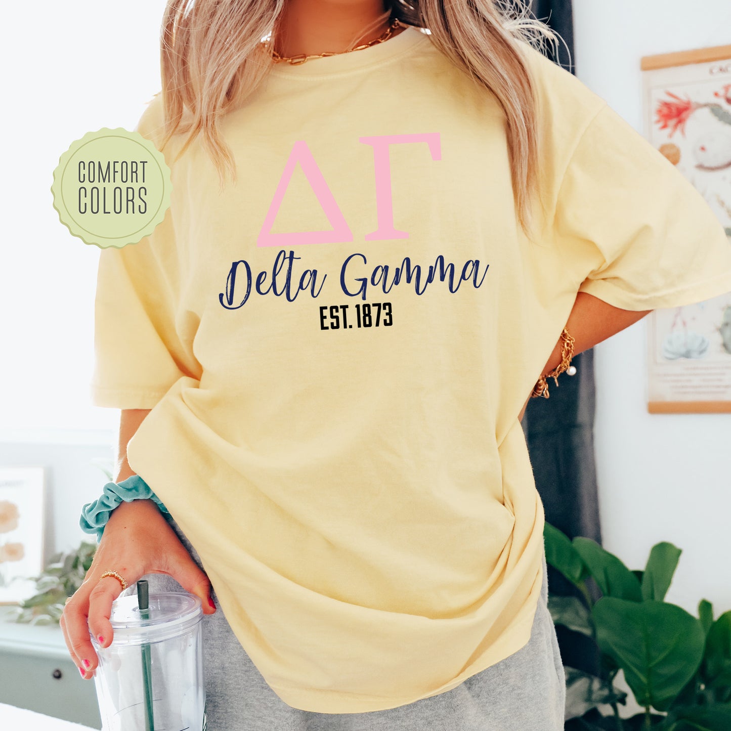 a woman wearing a yellow t - shirt with the words delta gama on it