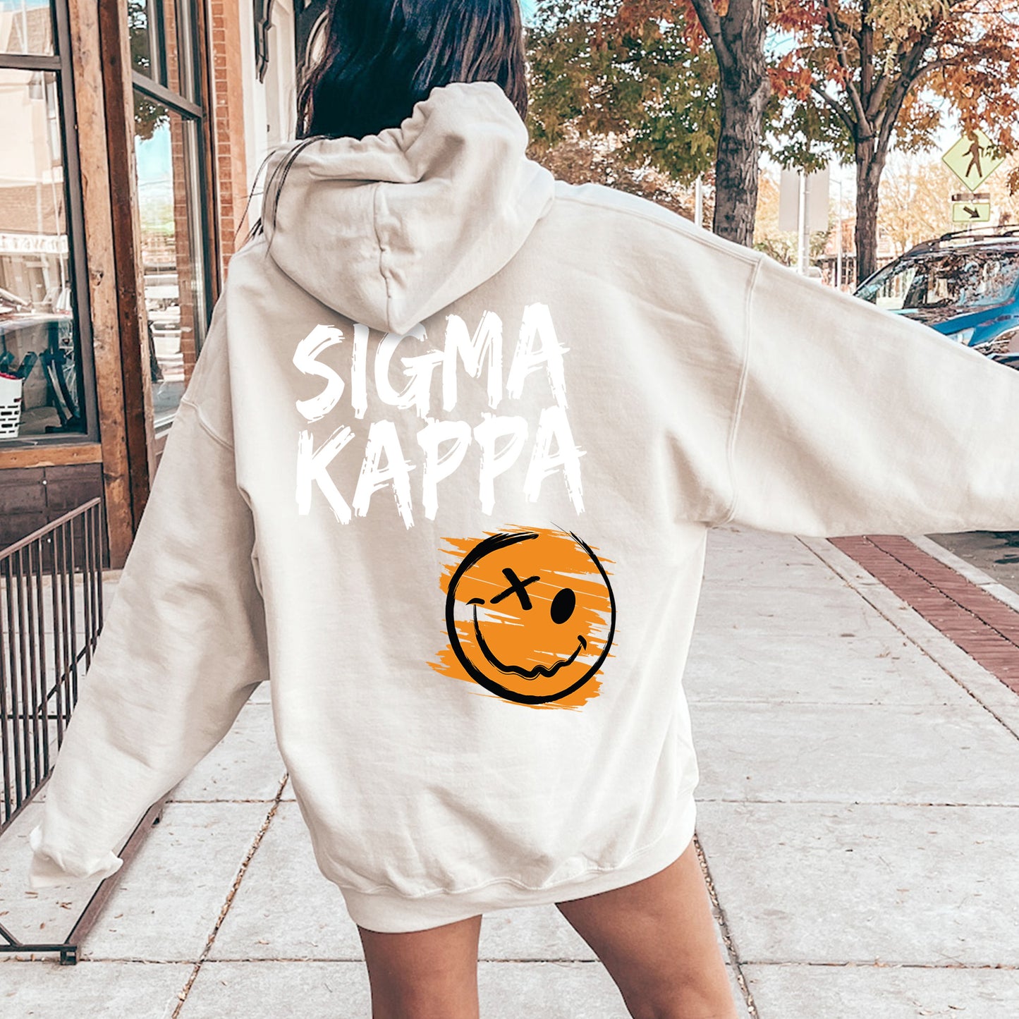 a woman in a white sweatshirt with a smiley face on it