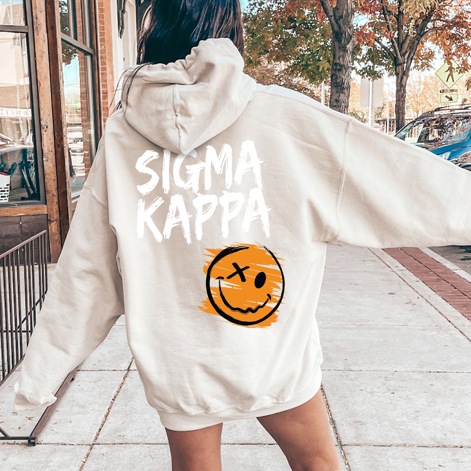 a woman in a white sweatshirt with a smiley face on it
