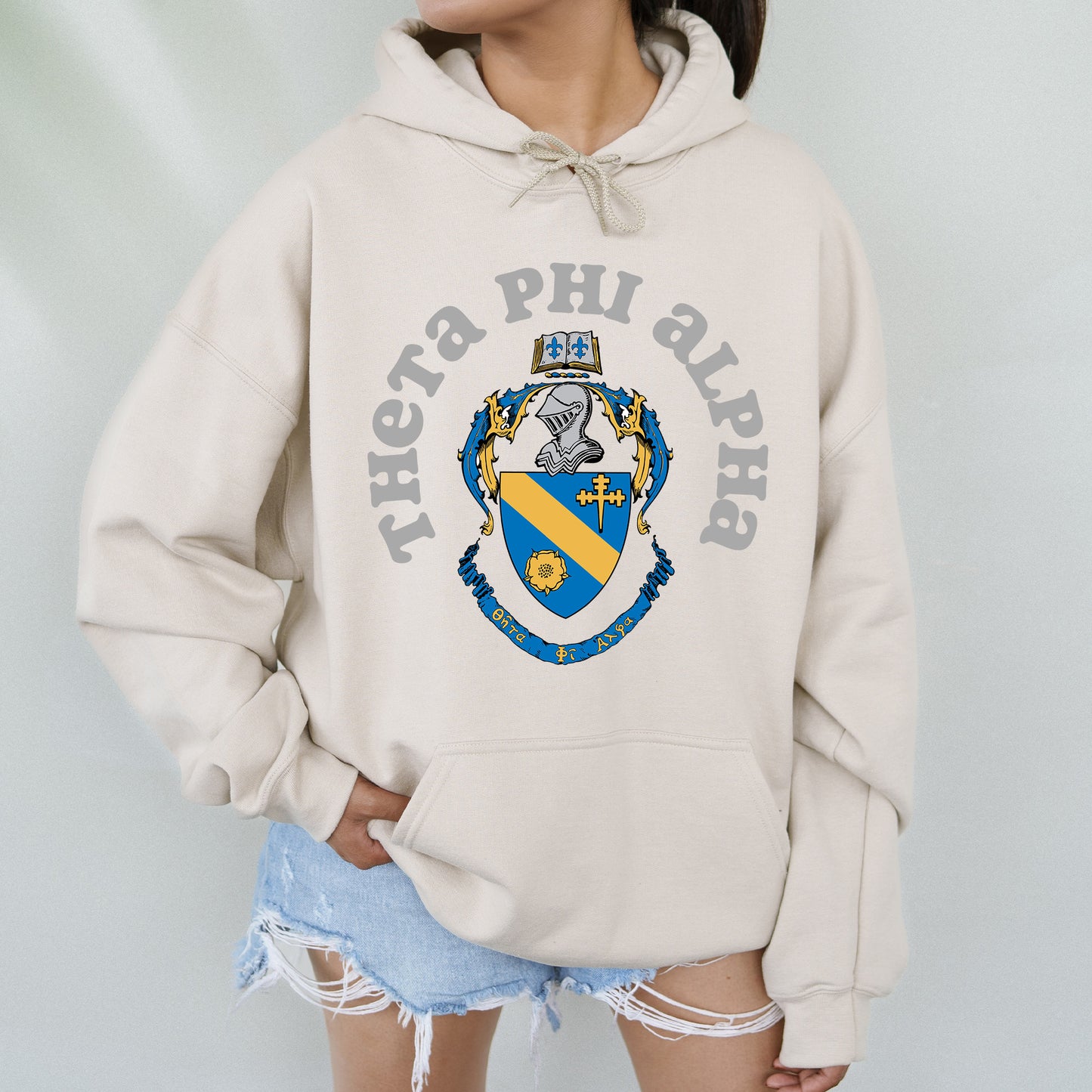 a woman wearing a white hoodie with a blue and yellow crest on it