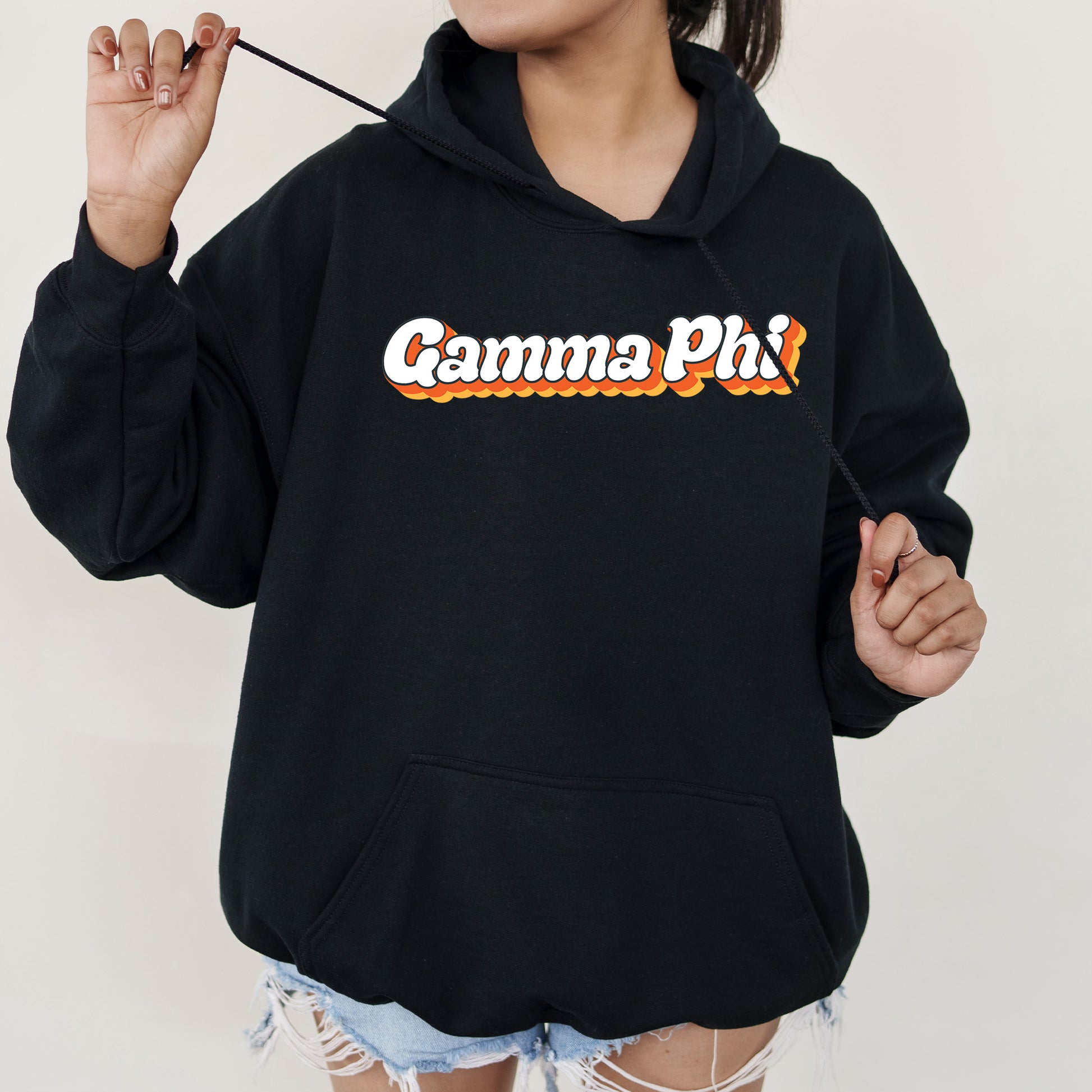 a woman in a black hoodie holding a stick