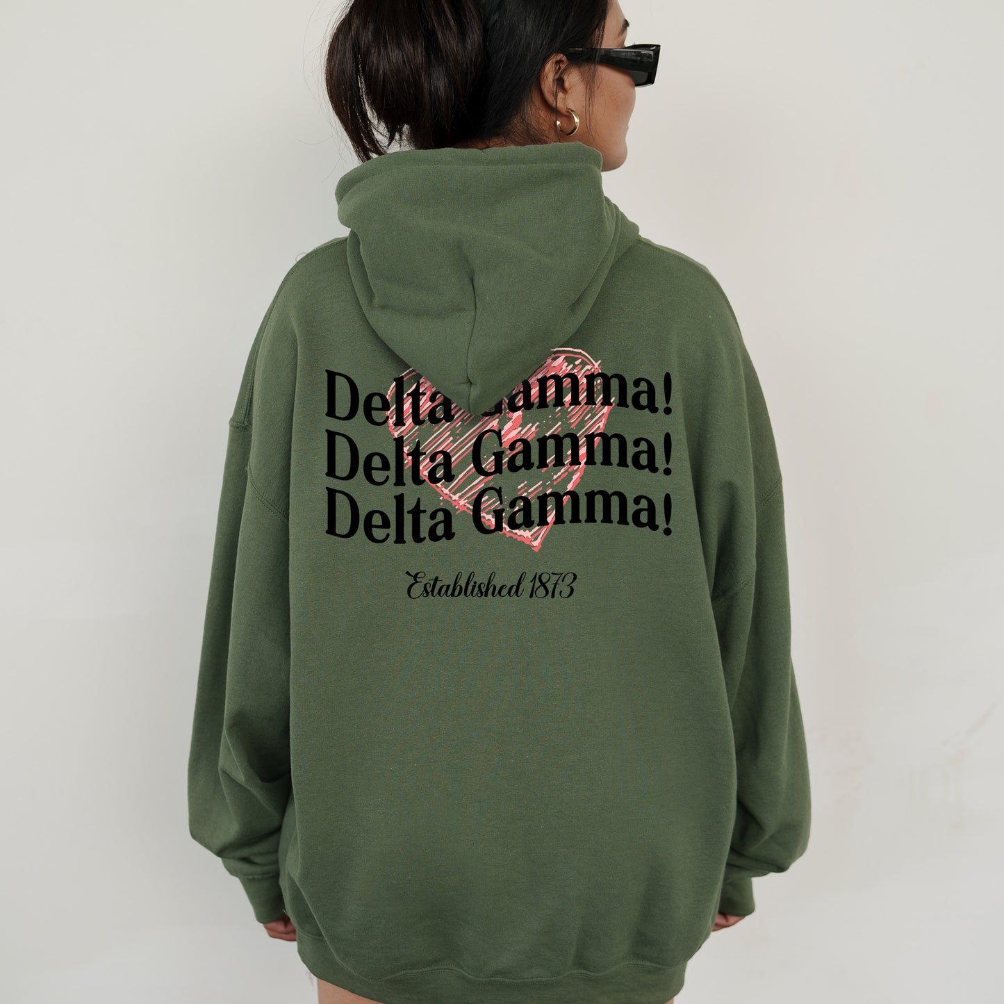 a woman wearing a green hoodie with a pink heart on it
