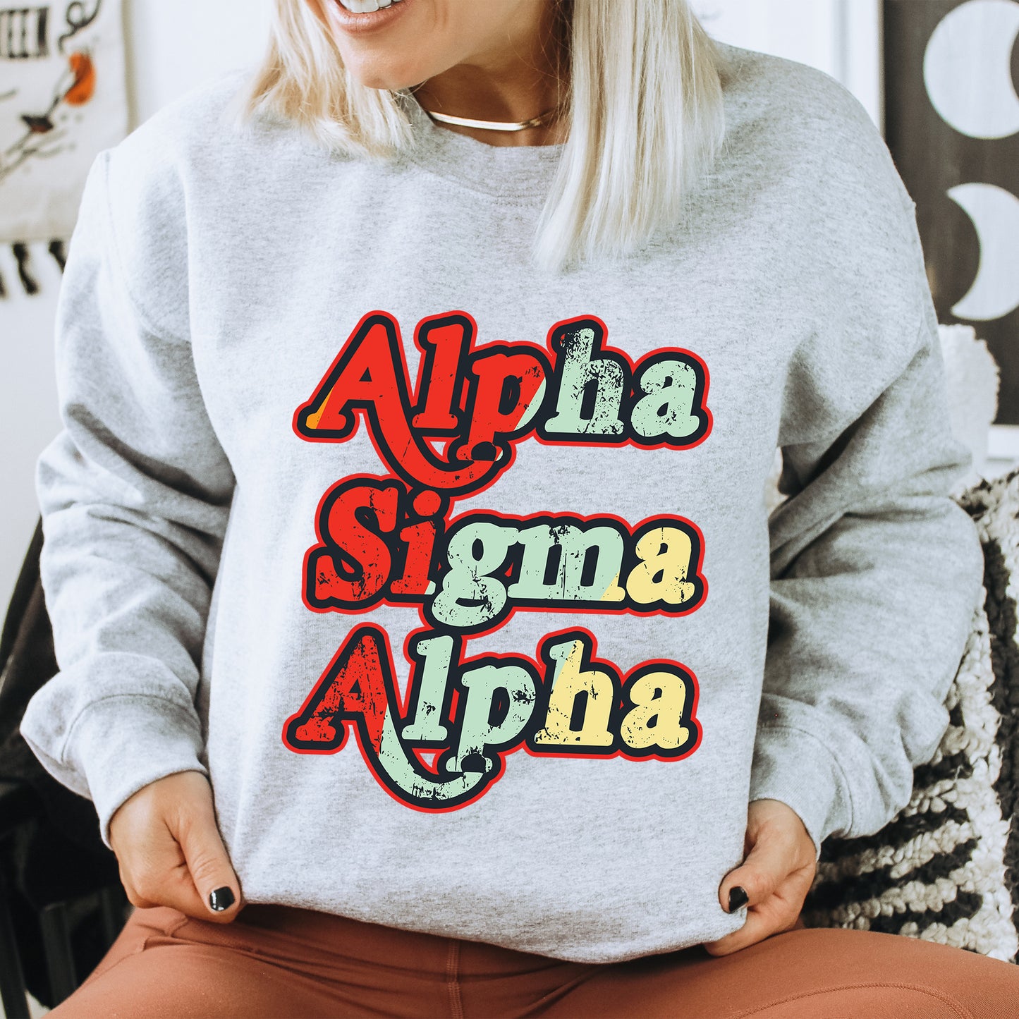 a woman sitting on a chair wearing a sweatshirt with the words aloha,