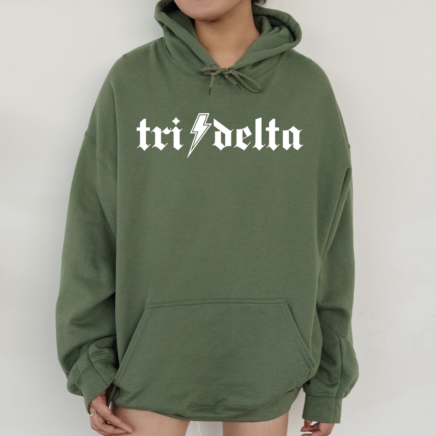 a woman wearing a green hoodie with the word tri - delta printed on it