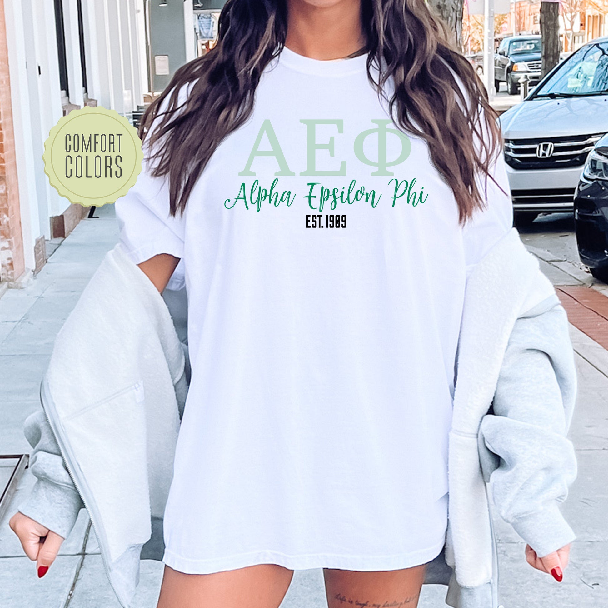 a woman wearing a white shirt with green letters on it