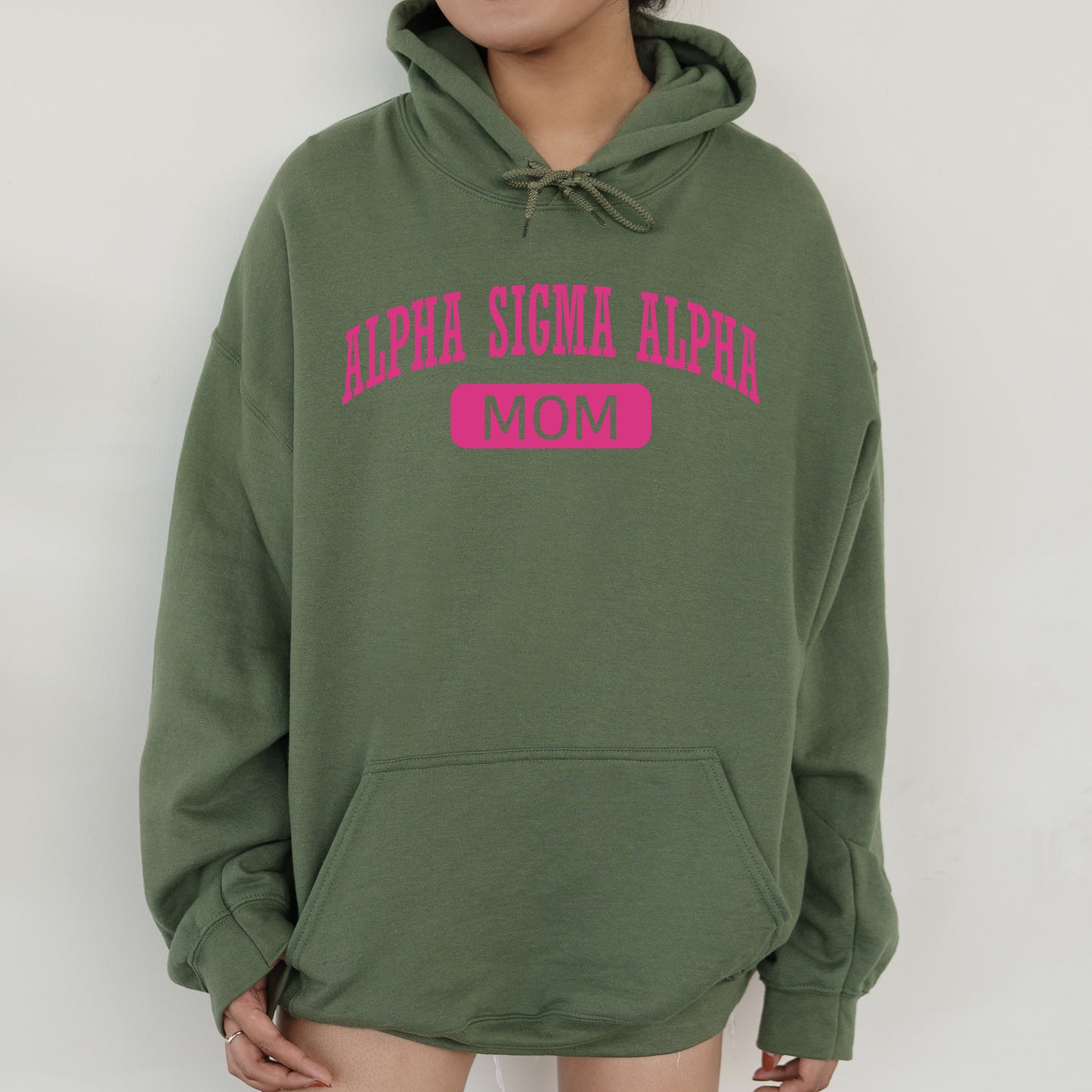 a woman wearing a green hoodie with pink letters