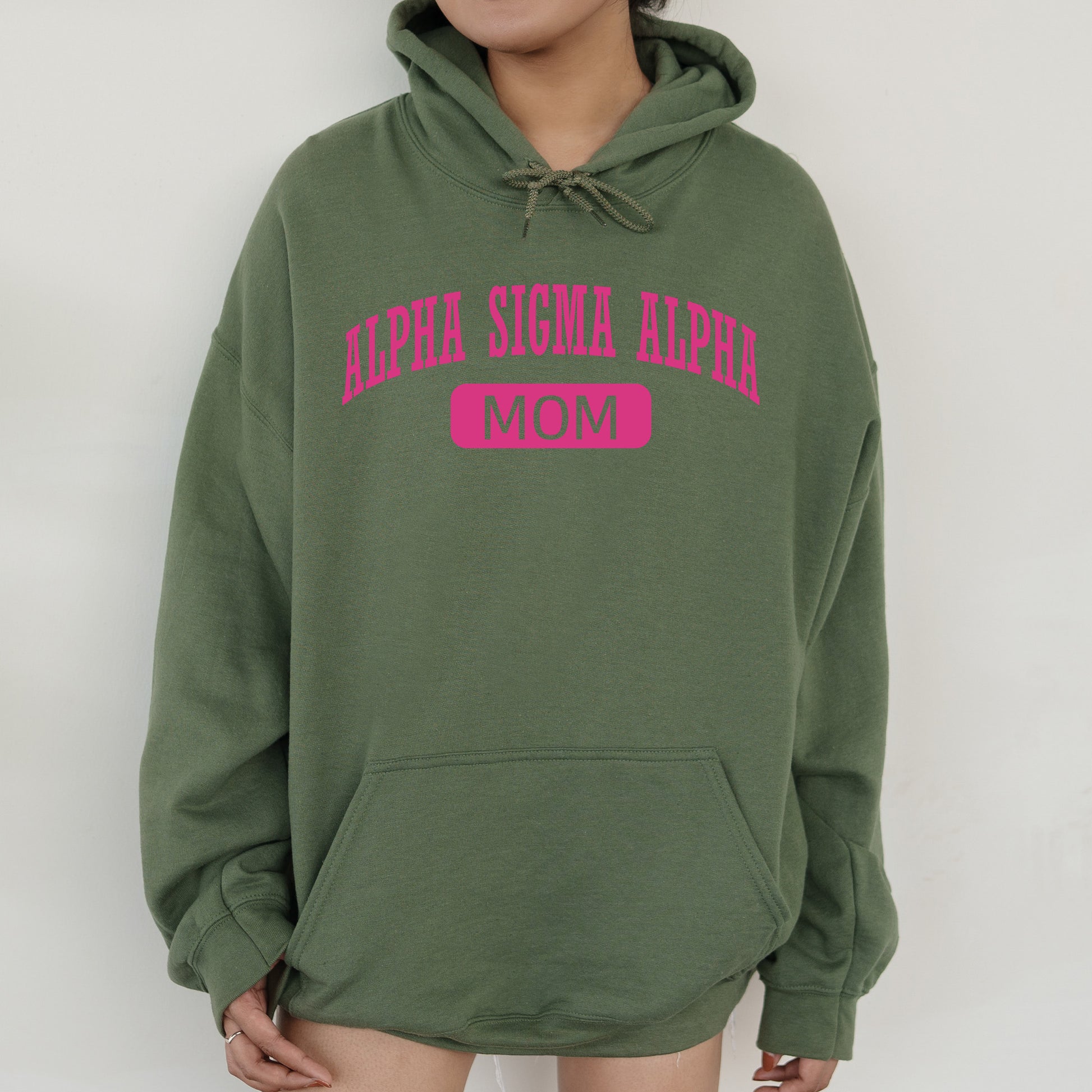 a woman wearing a green hoodie with pink letters