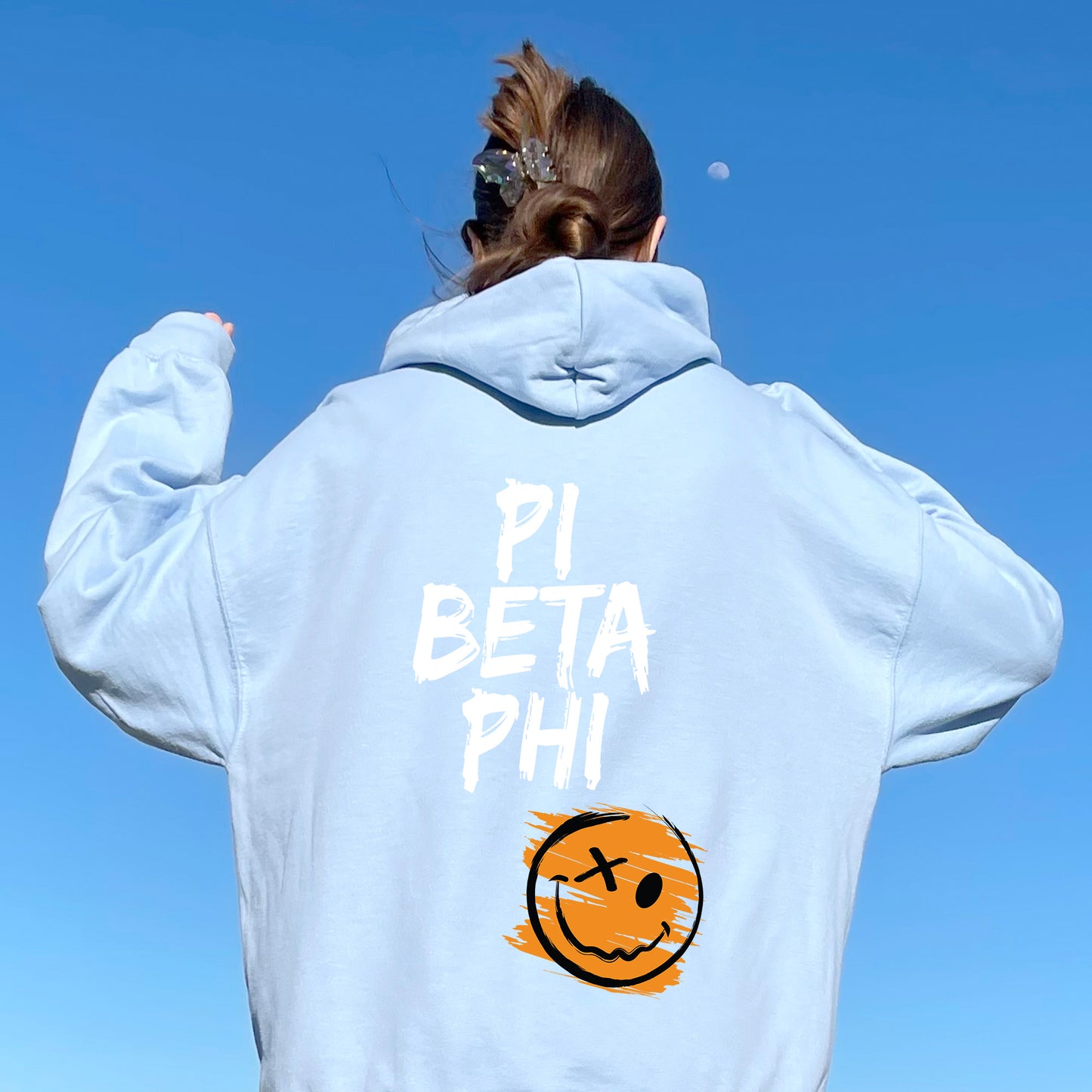 a woman wearing a hoodie that says pi beta phi