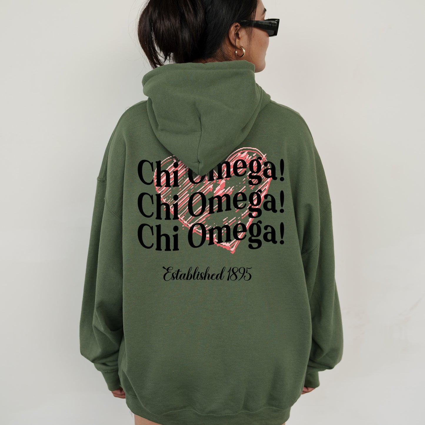 a woman wearing a green hoodie with a pink heart on it