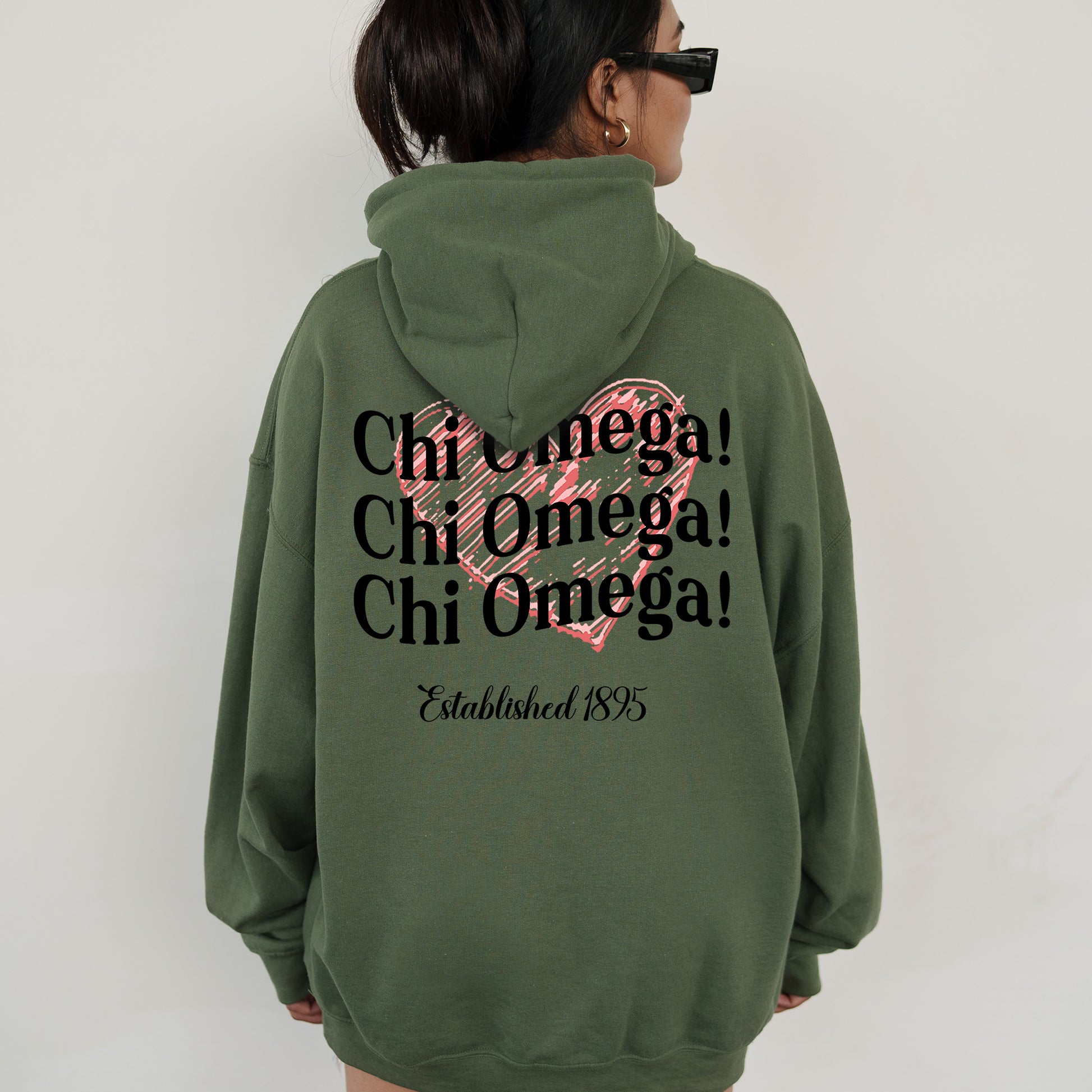 a woman wearing a green hoodie with a pink heart on it