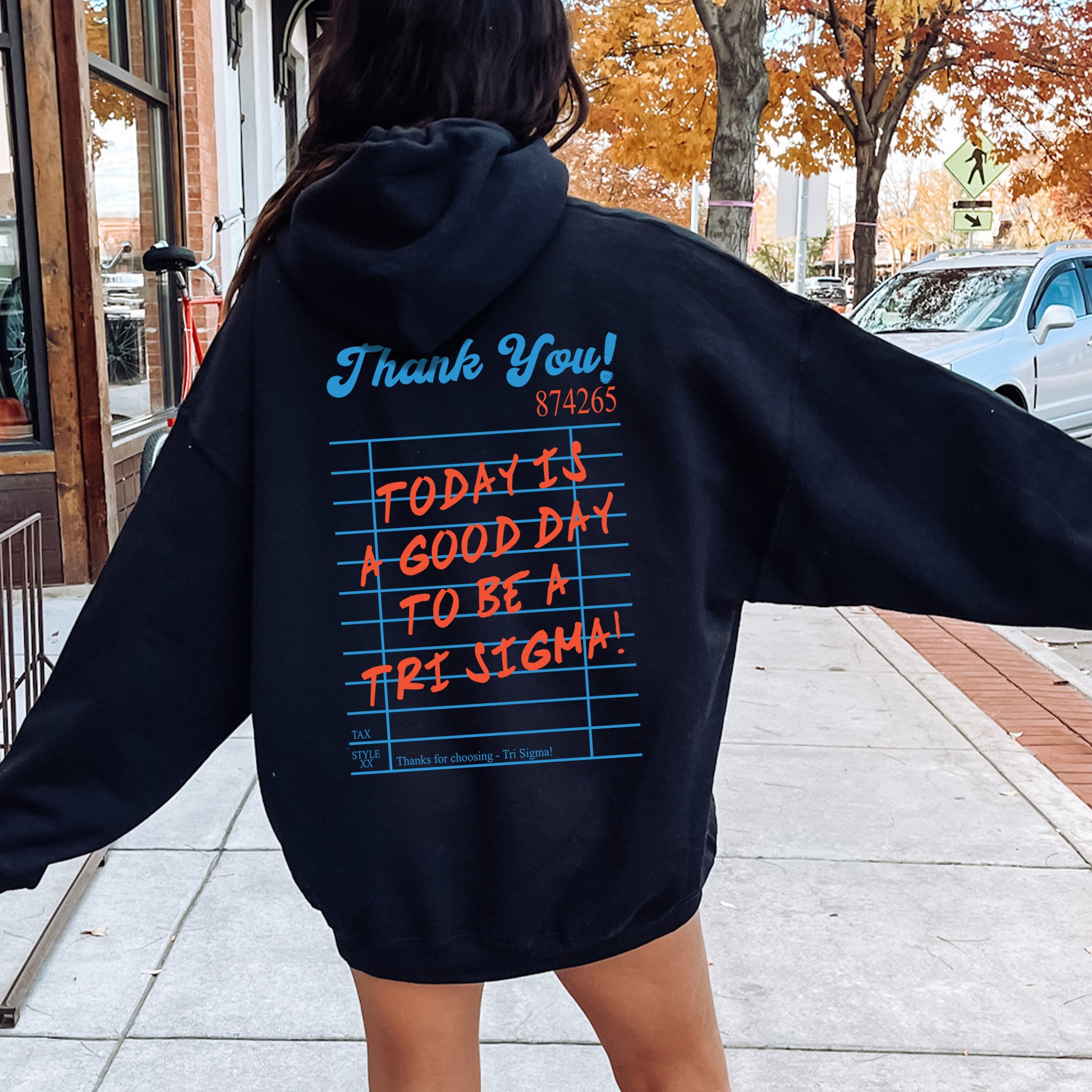 a woman in a black hoodie is walking down the street