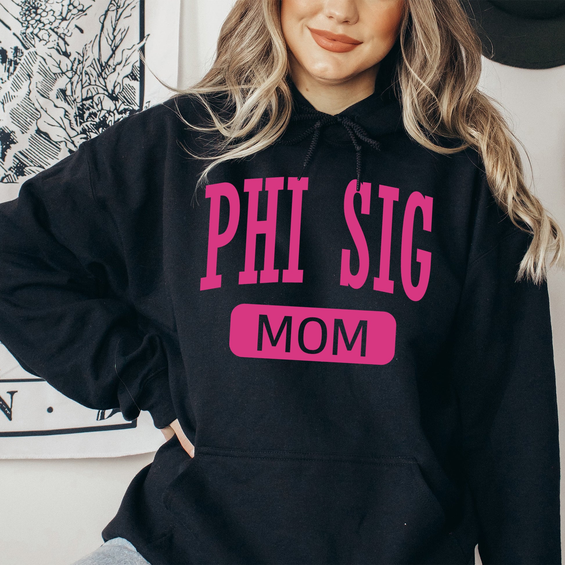 a woman wearing a phi sig mom hoodie