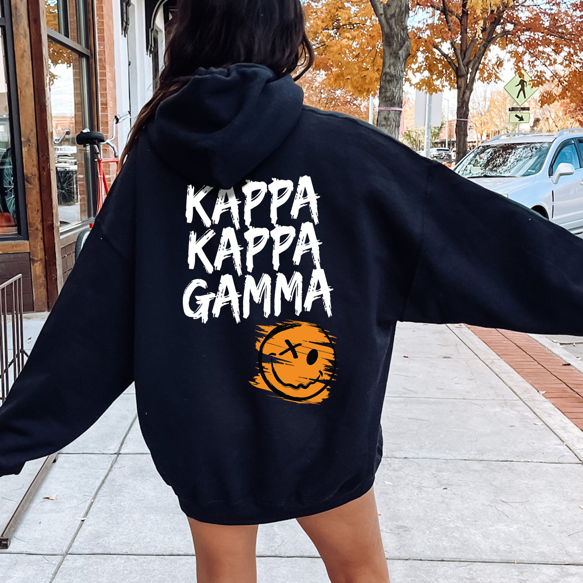 a woman in a black hoodie is walking down the street