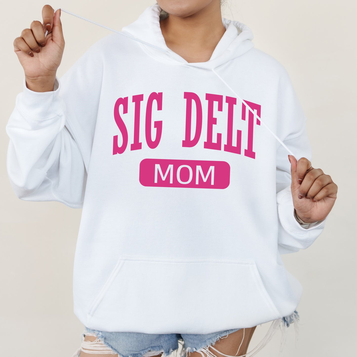 a woman wearing a white sweatshirt that says, sig delf mom