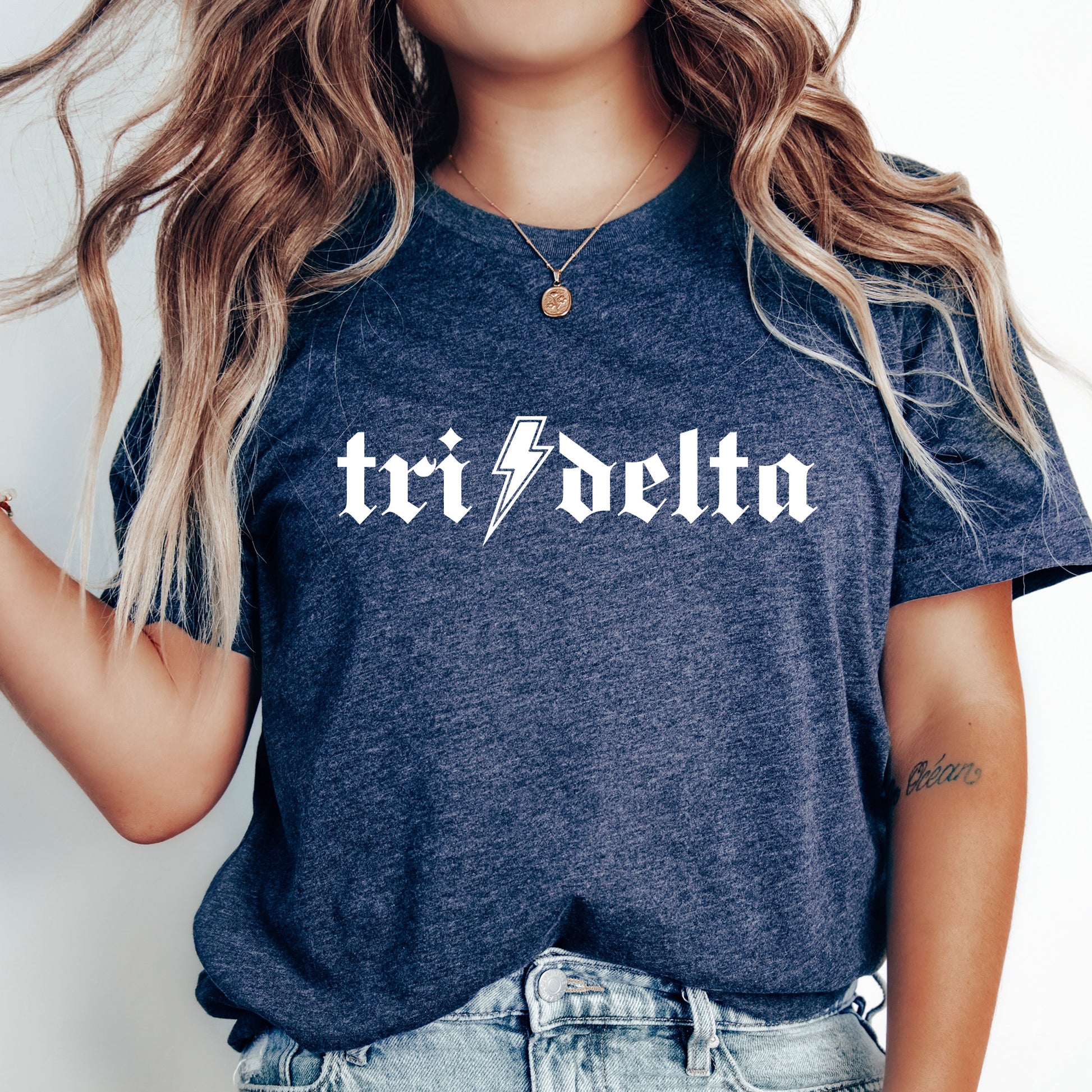 a woman wearing a t - shirt with the word tri delta printed on it