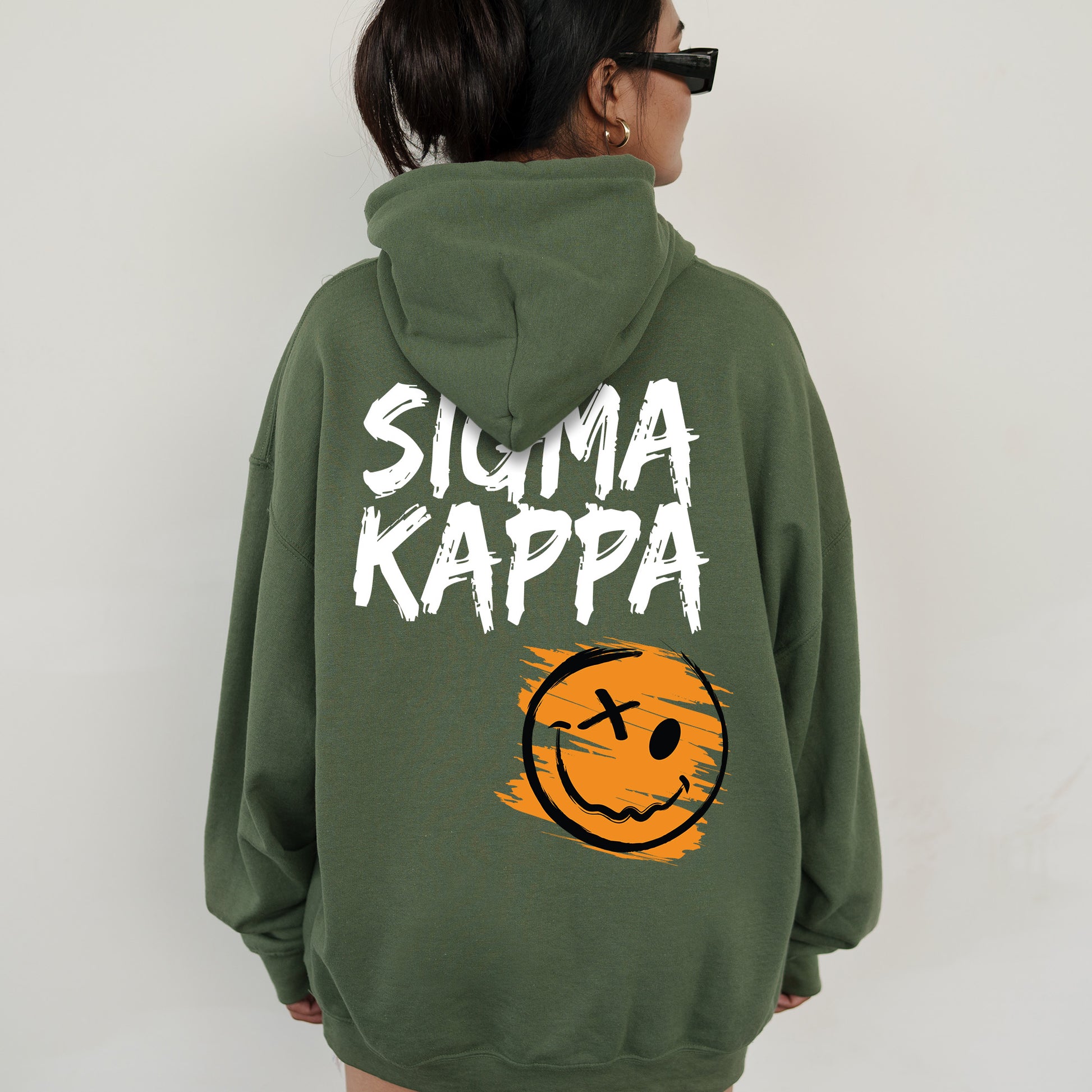 a woman wearing a green hoodie with a smiley face on it