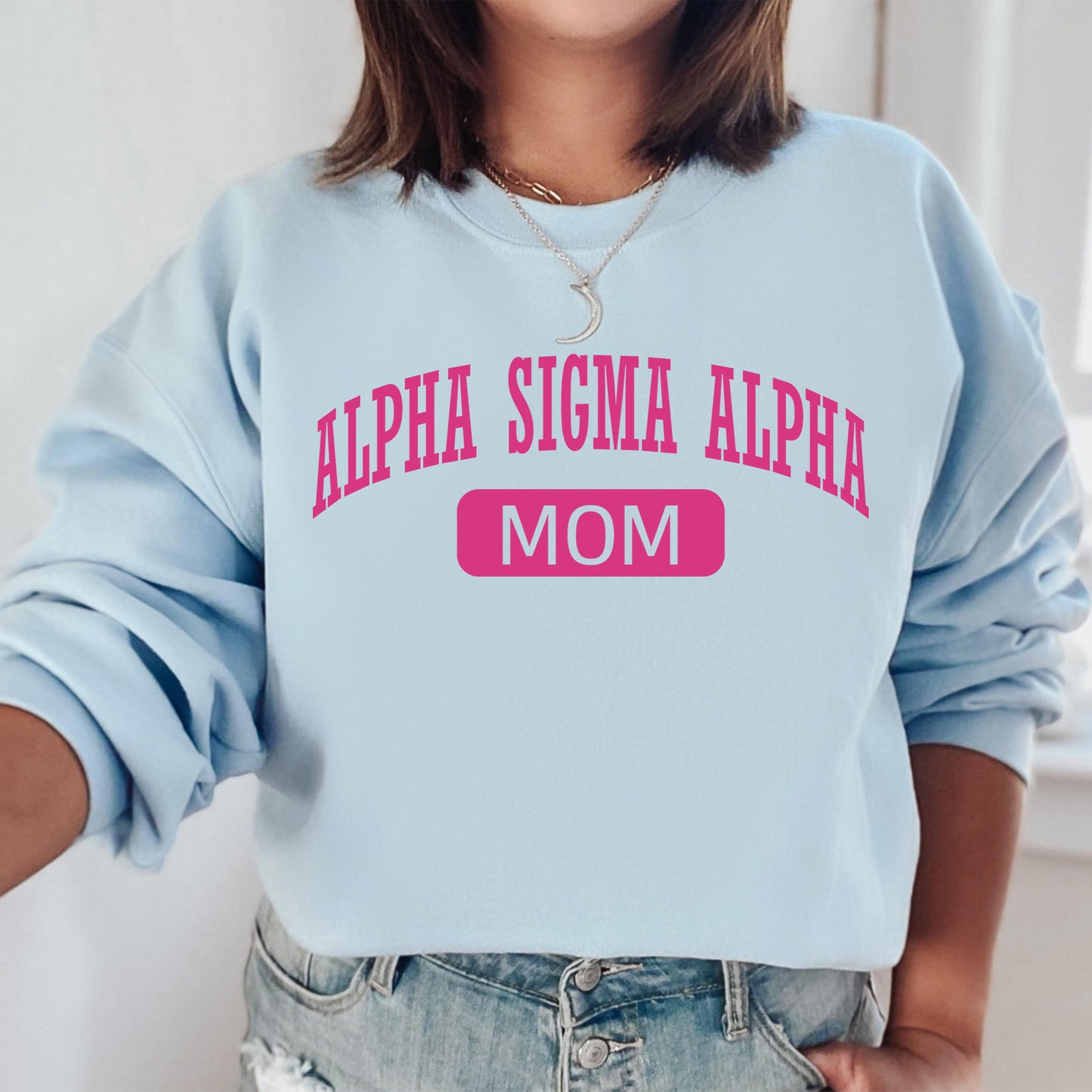 a woman wearing a blue sweatshirt with pink letters on it