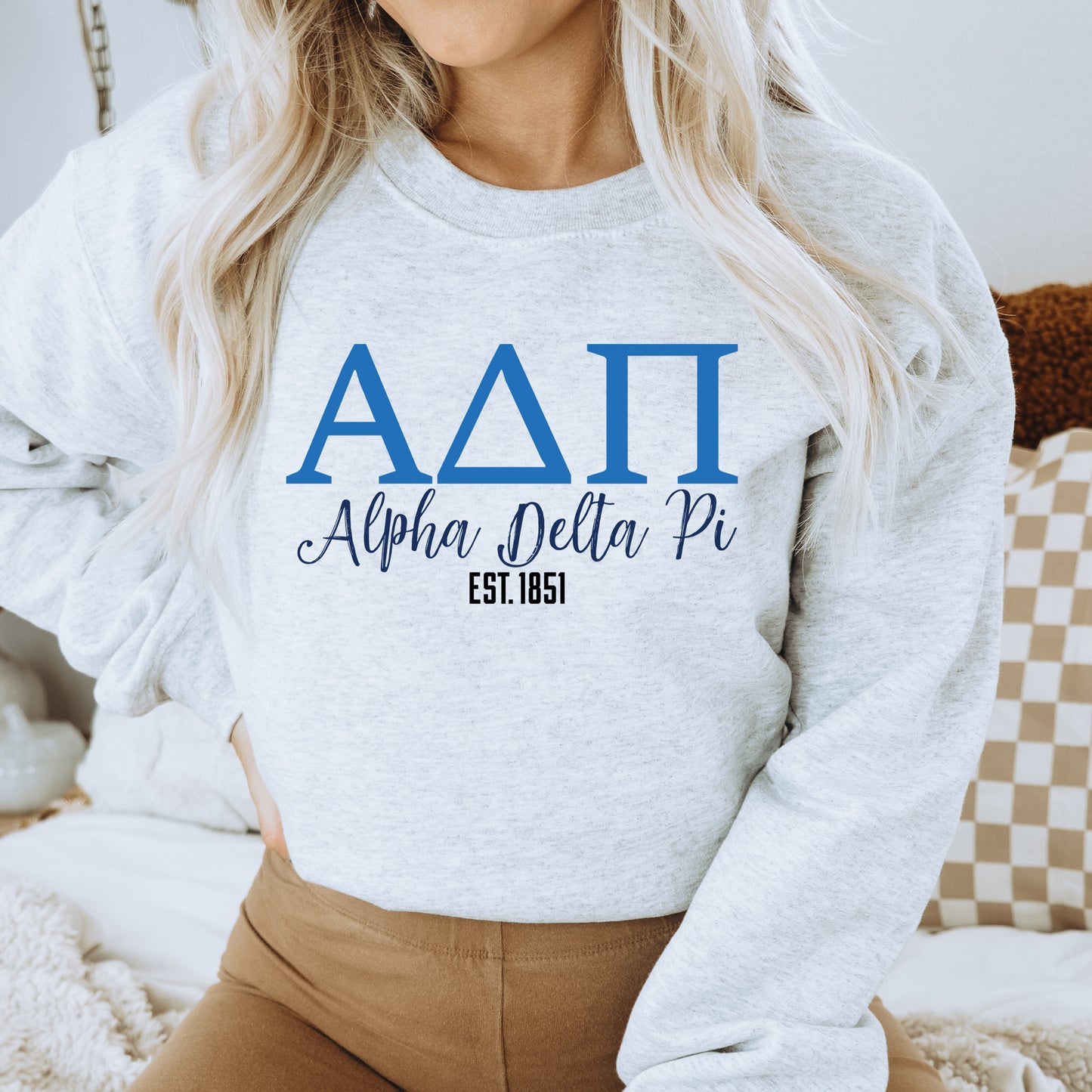 a woman wearing a sweatshirt that reads aati alpna delta pi est est