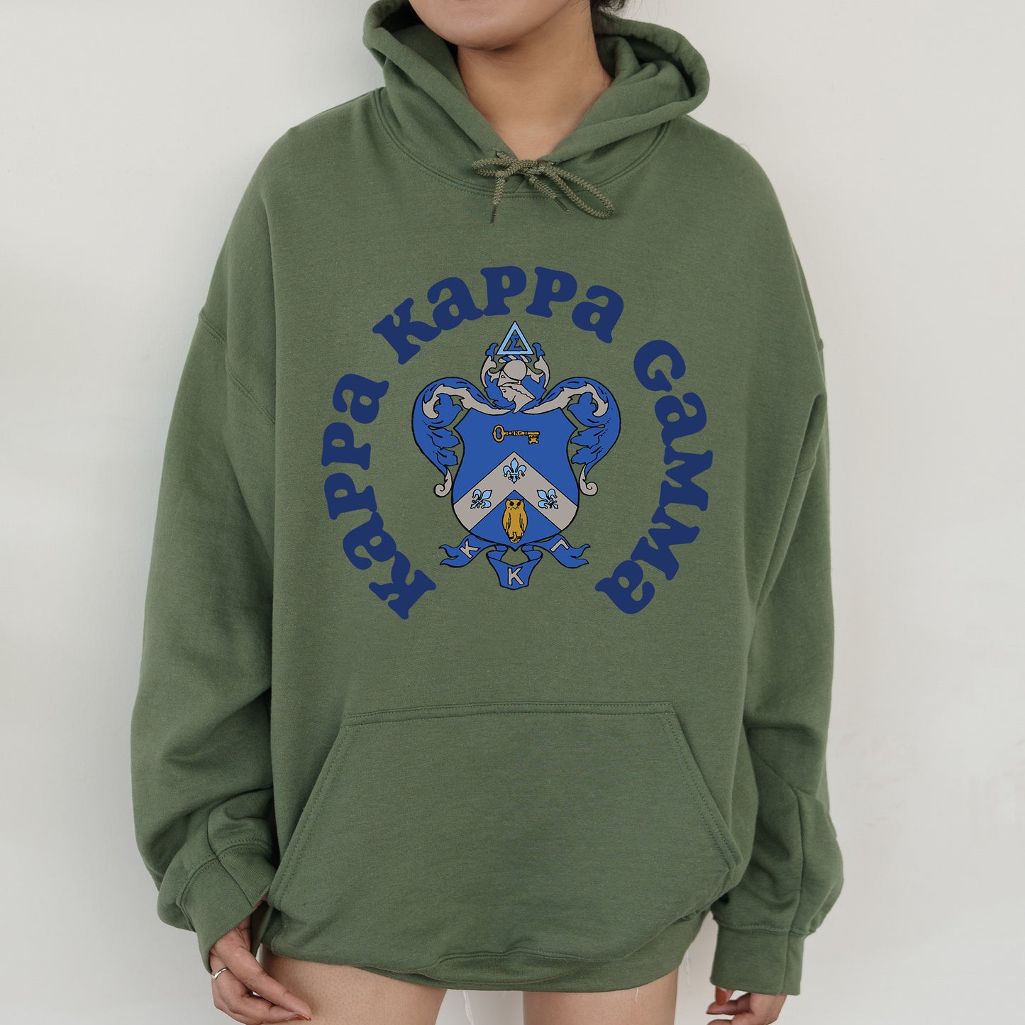 a person wearing a green hoodie with a blue and white dragon on it