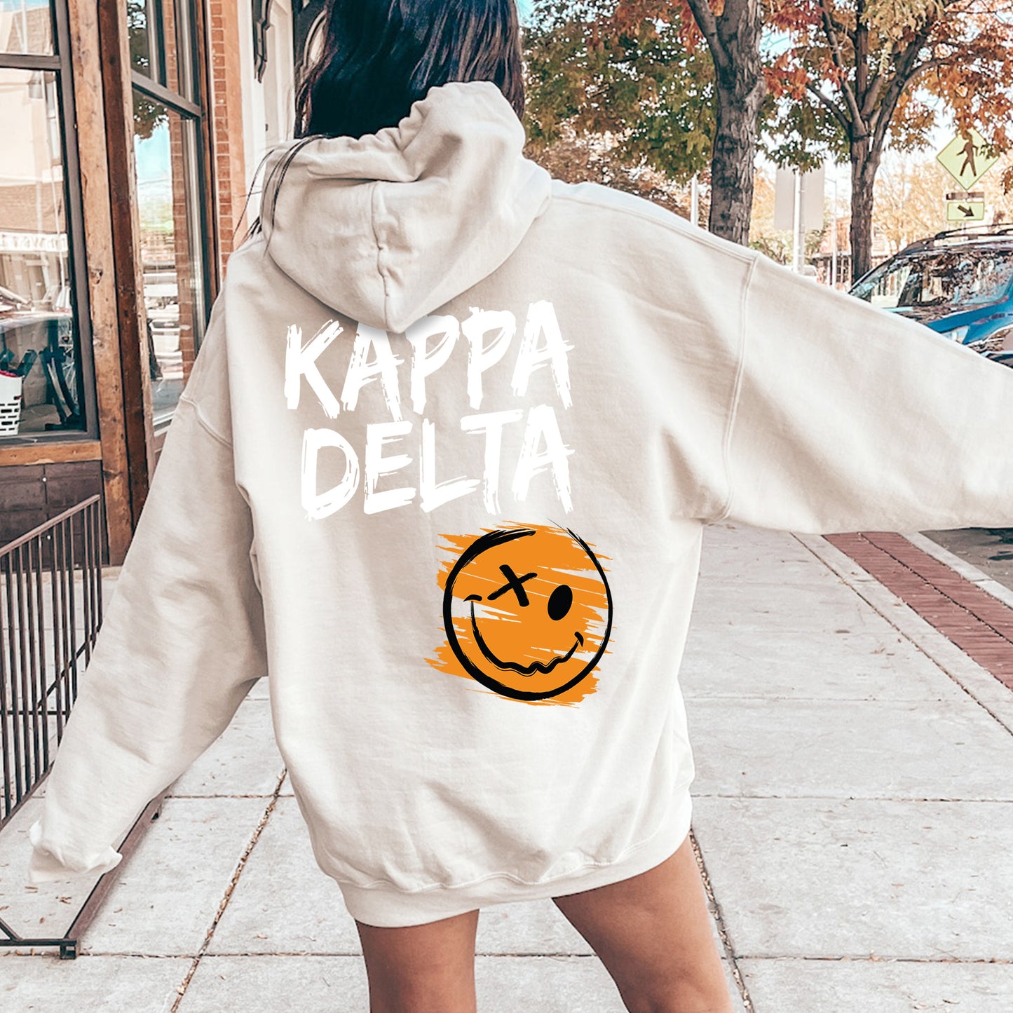 a woman in a white sweatshirt with a smiley face on it