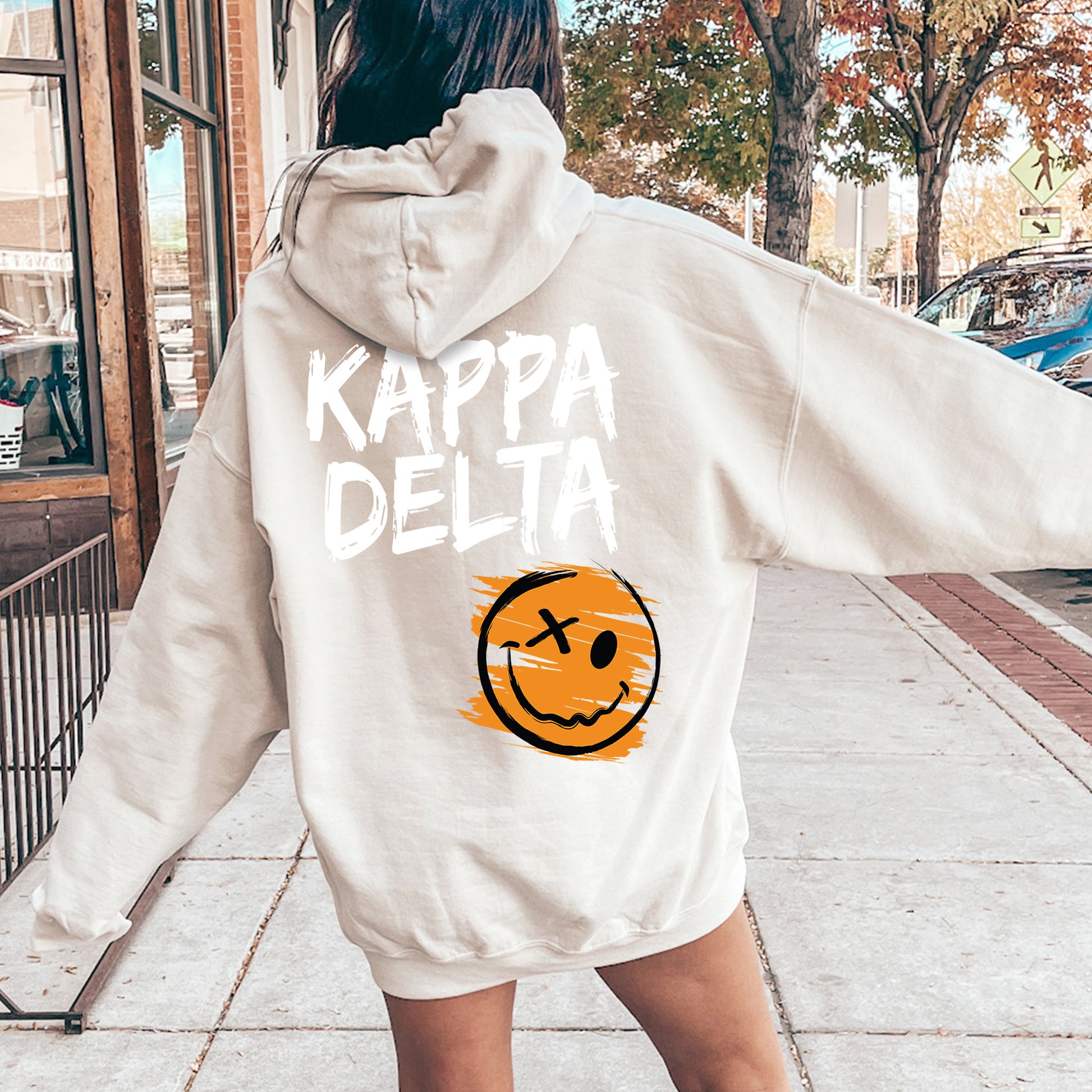 a woman in a white sweatshirt with a smiley face on it