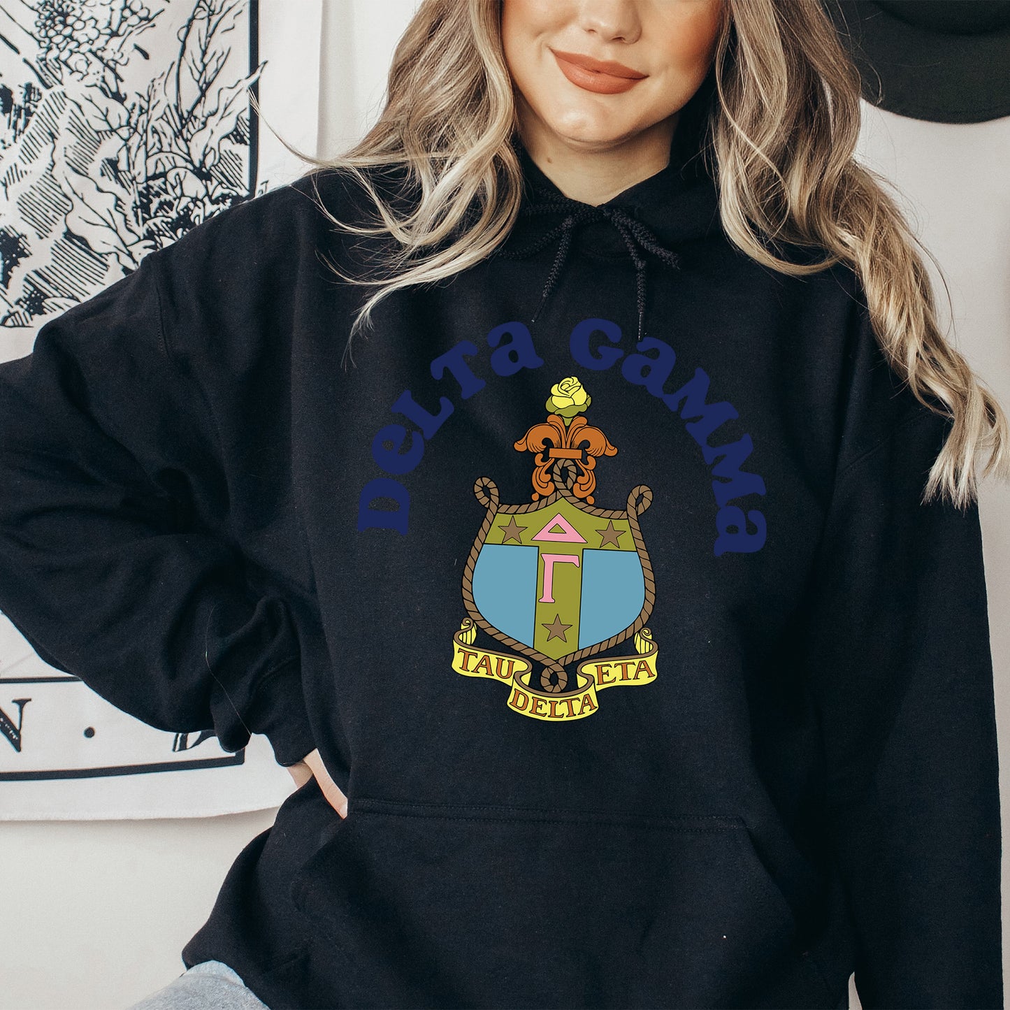 a woman wearing a black hoodie with a coat of arms on it