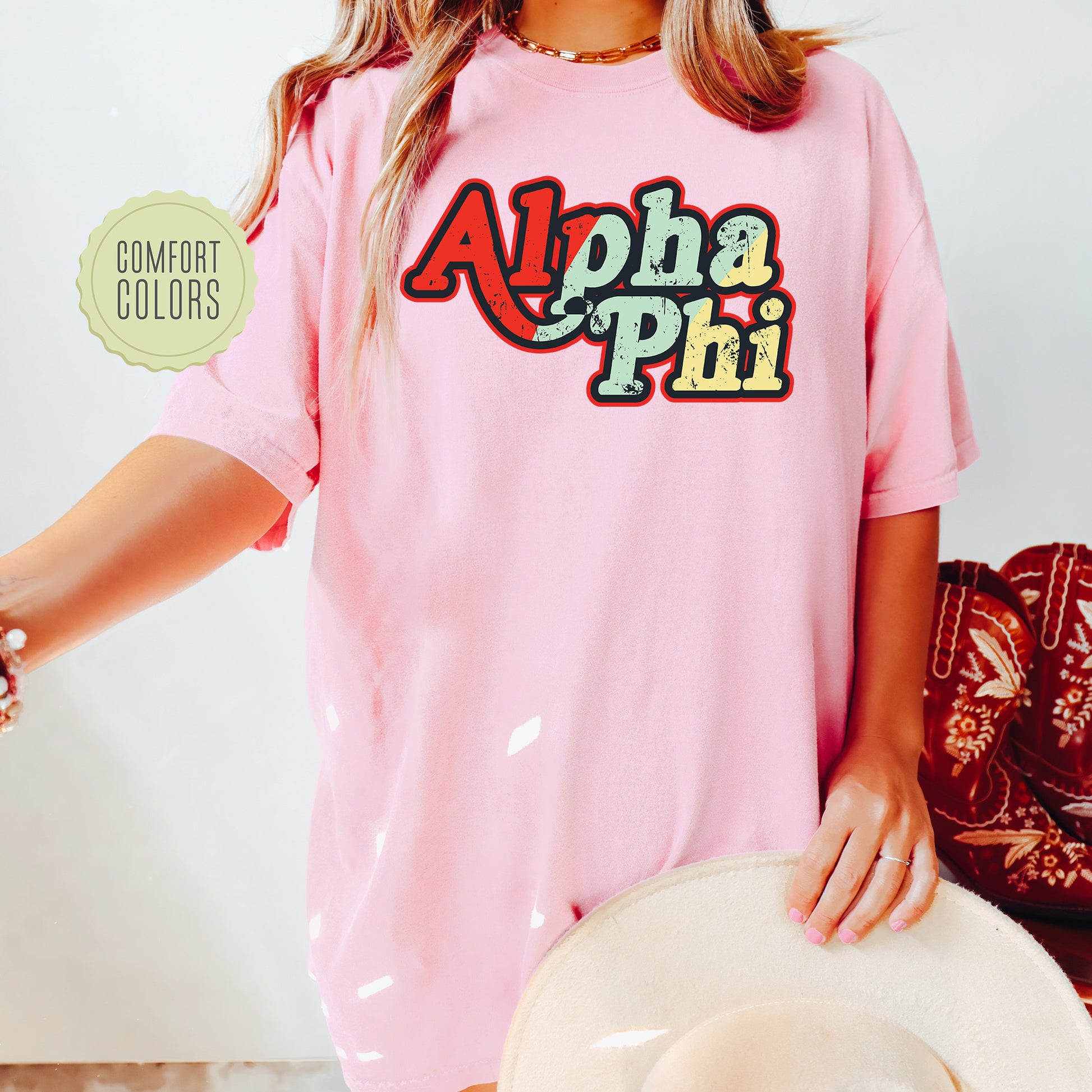 a woman wearing a pink shirt with the word aloha phi on it