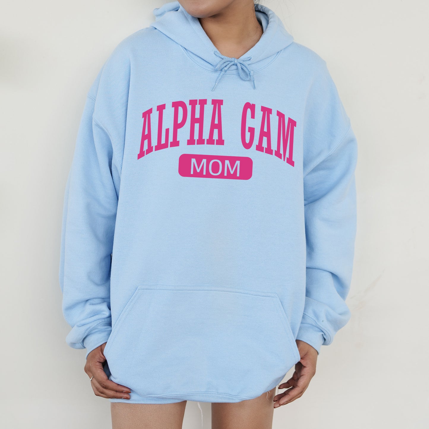 a woman wearing a light blue hoodie with pink letters