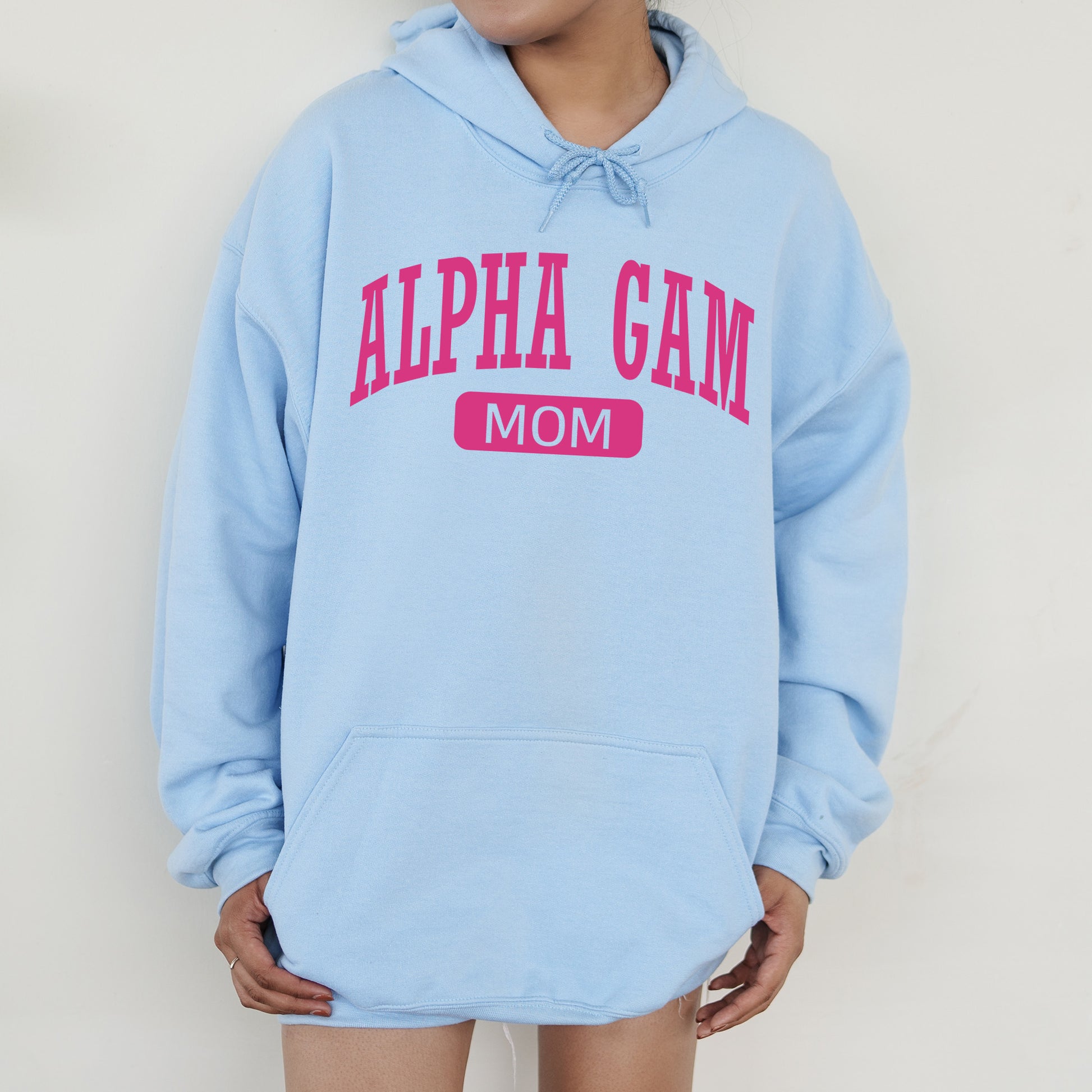 a woman wearing a light blue hoodie with pink letters
