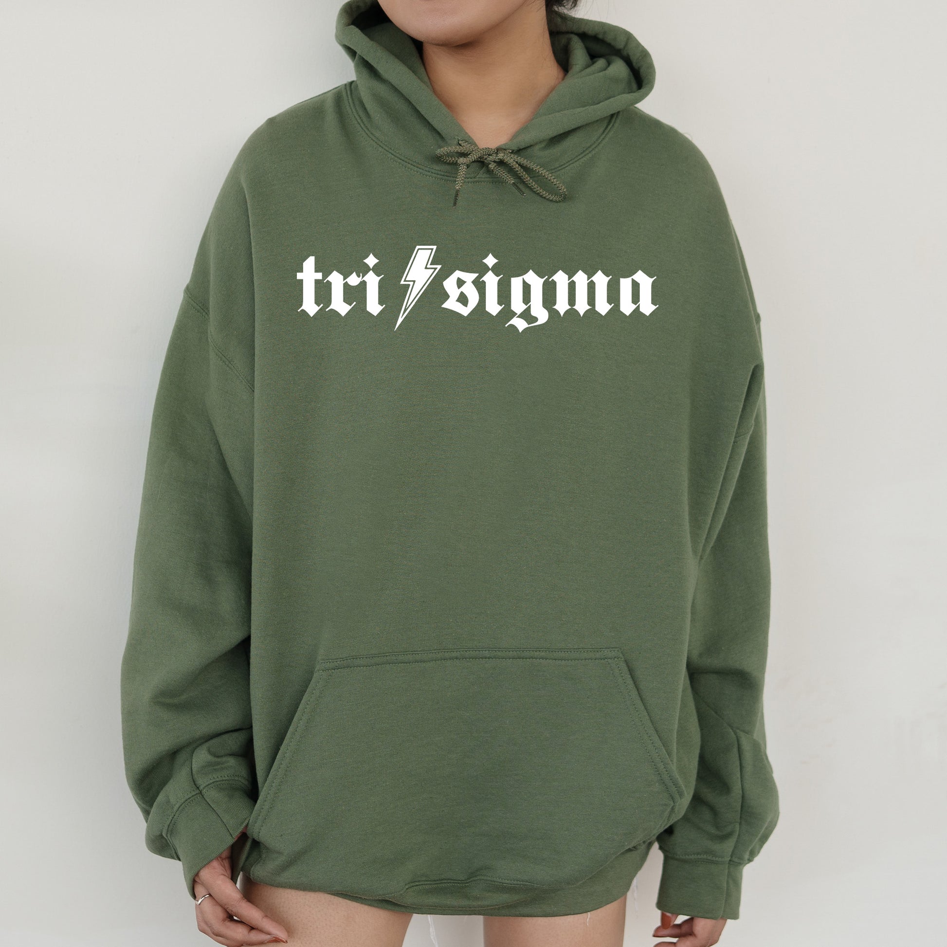a woman wearing a green sweatshirt with the word tri stigma printed on it