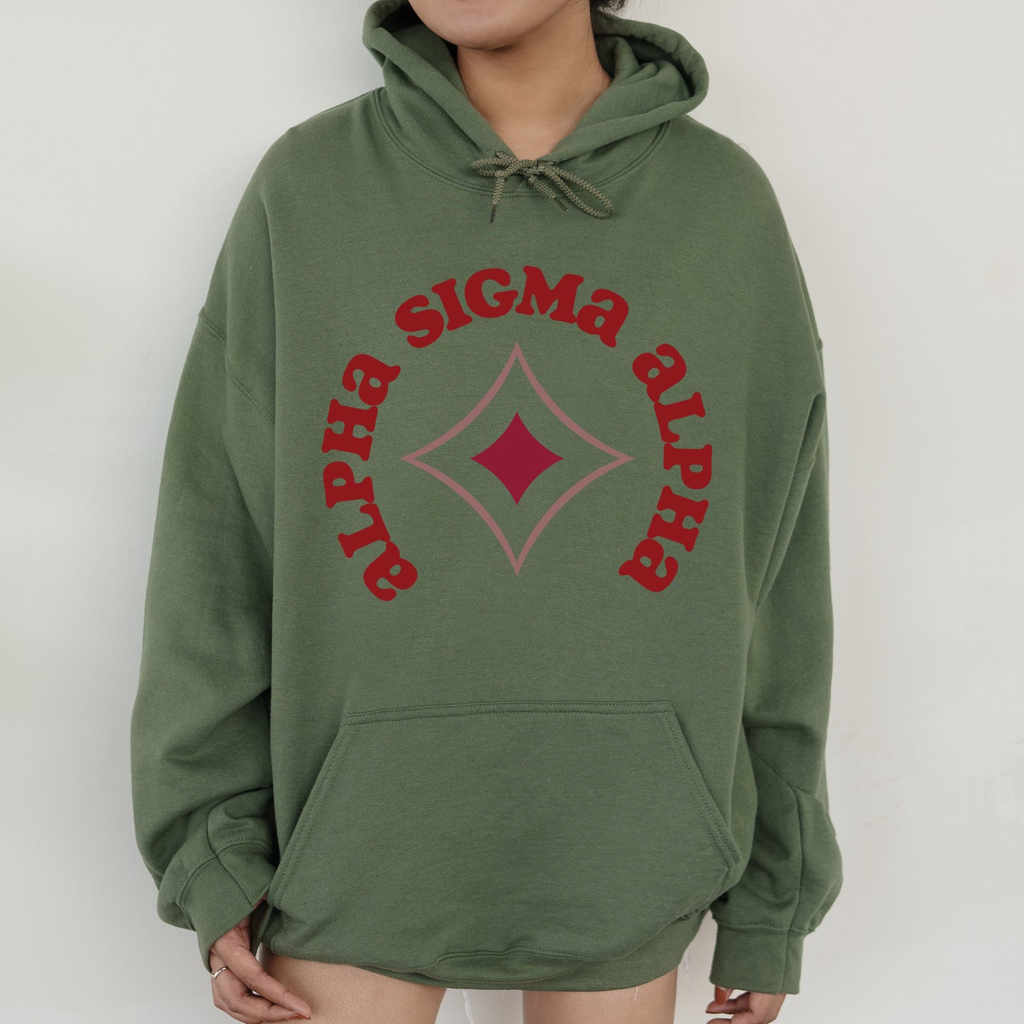 a woman wearing a green sweatshirt with a diamond on it