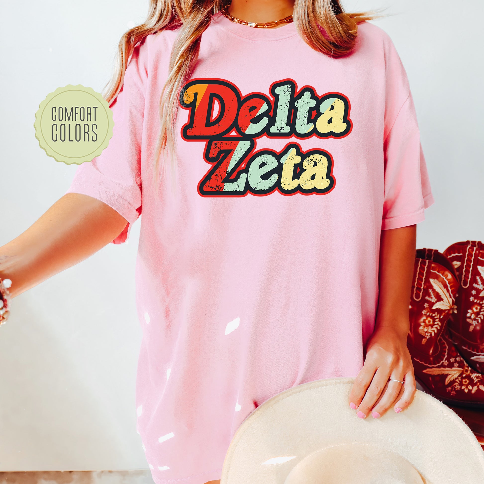 a woman wearing a pink delta zeta t - shirt