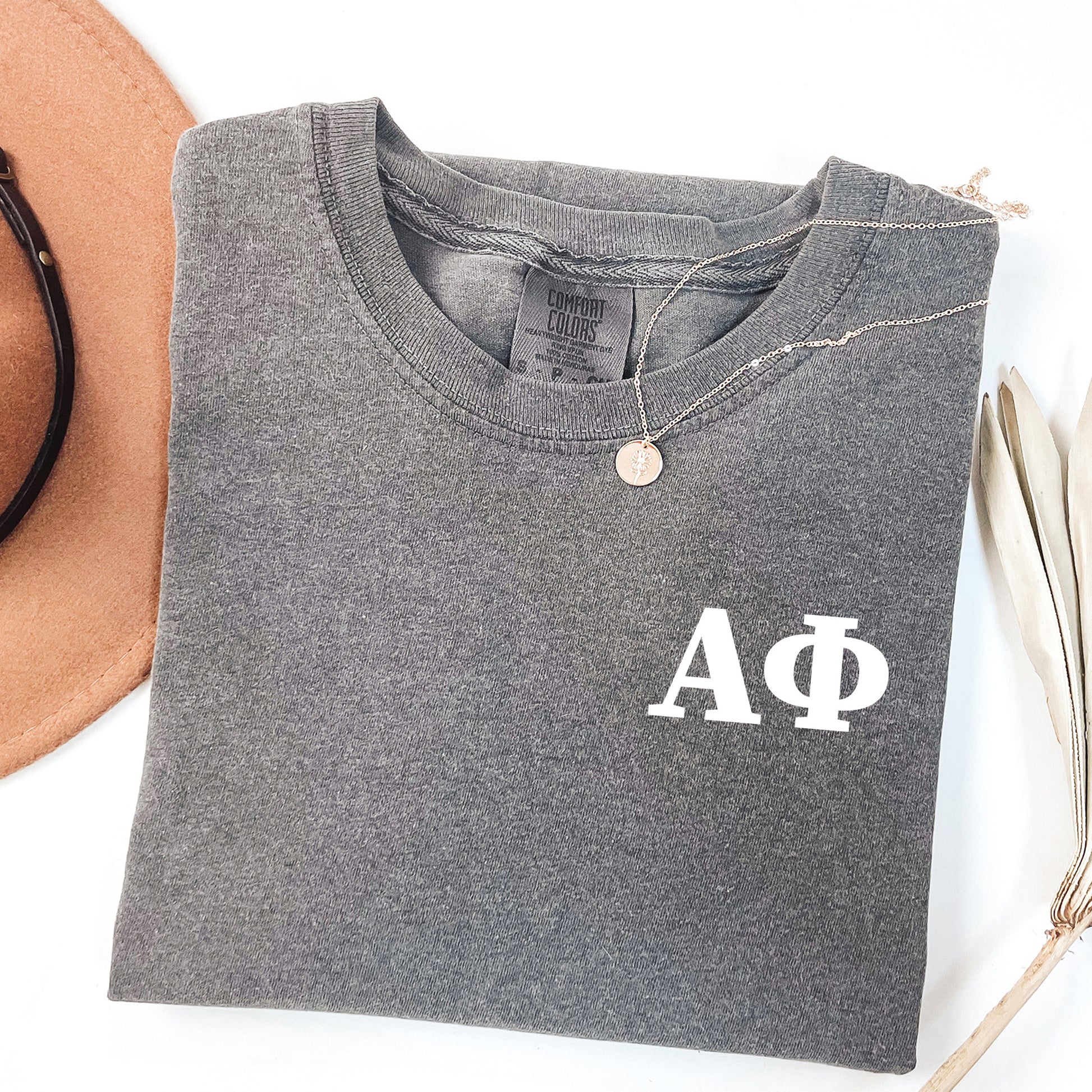 a hat, sunglasses, and a t - shirt on a white surface