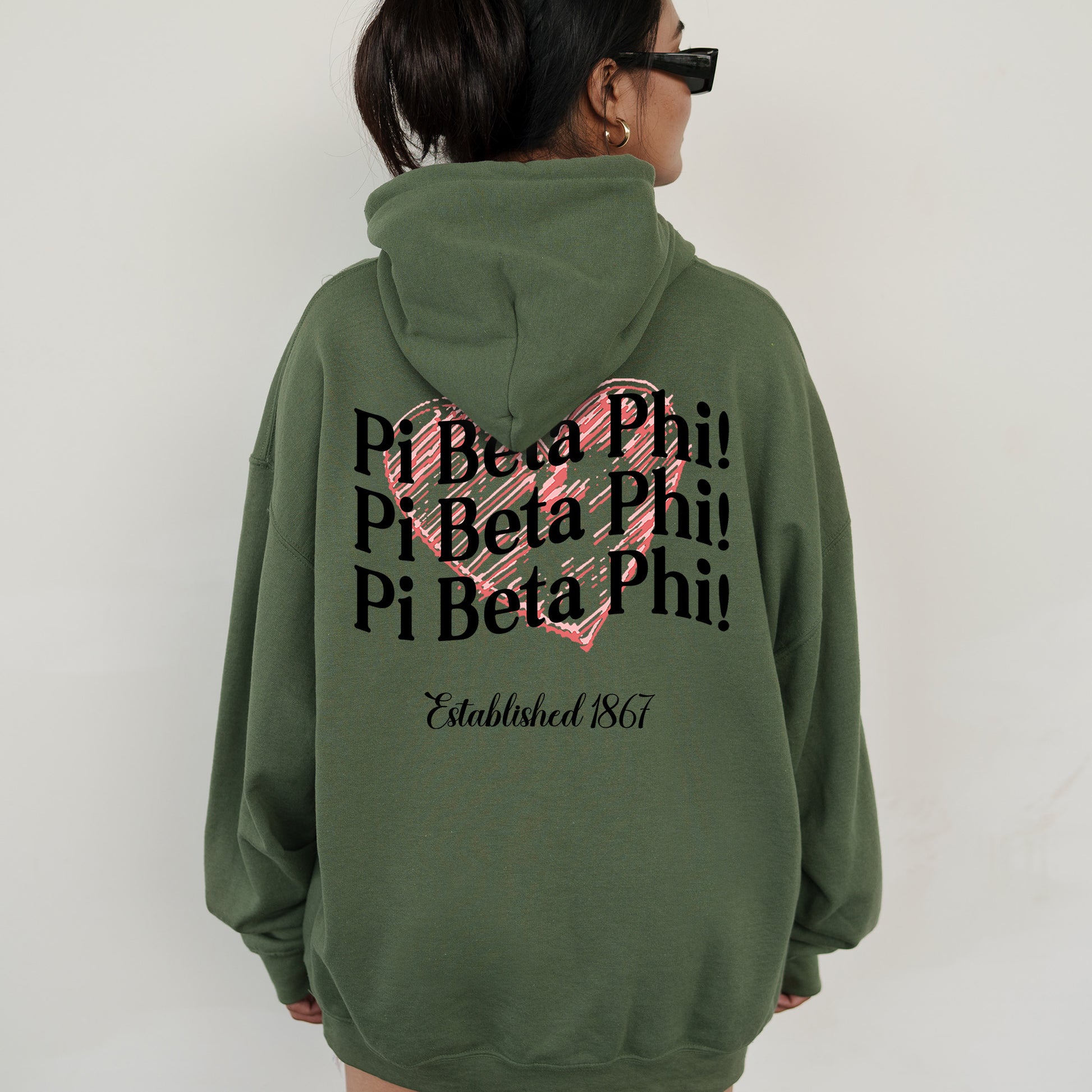a woman wearing a green hoodie with a pink heart on it