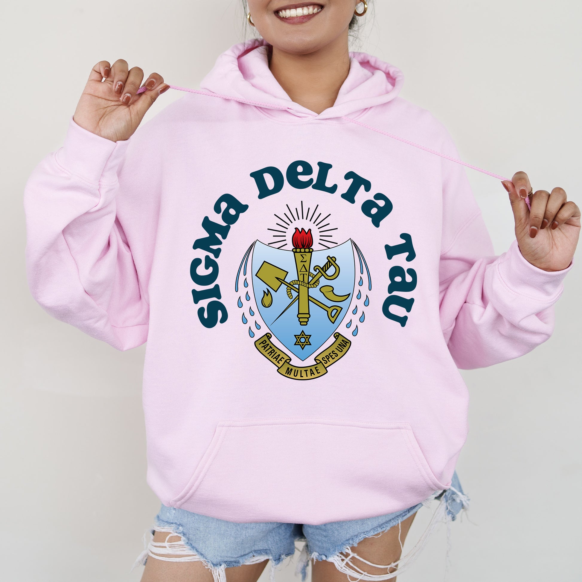 a woman wearing a pink hoodie with a coat of arms in front of her