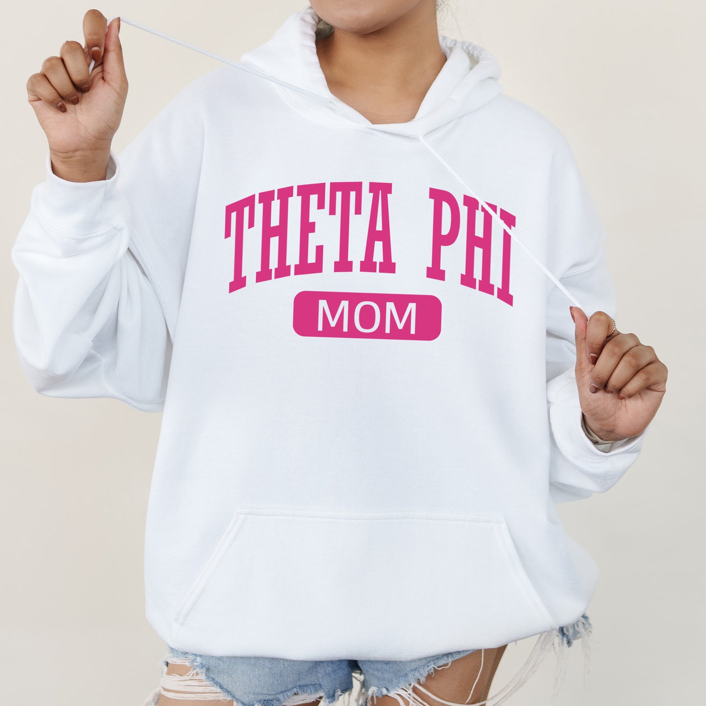 a woman wearing a white sweatshirt with the words thea phi mom on it