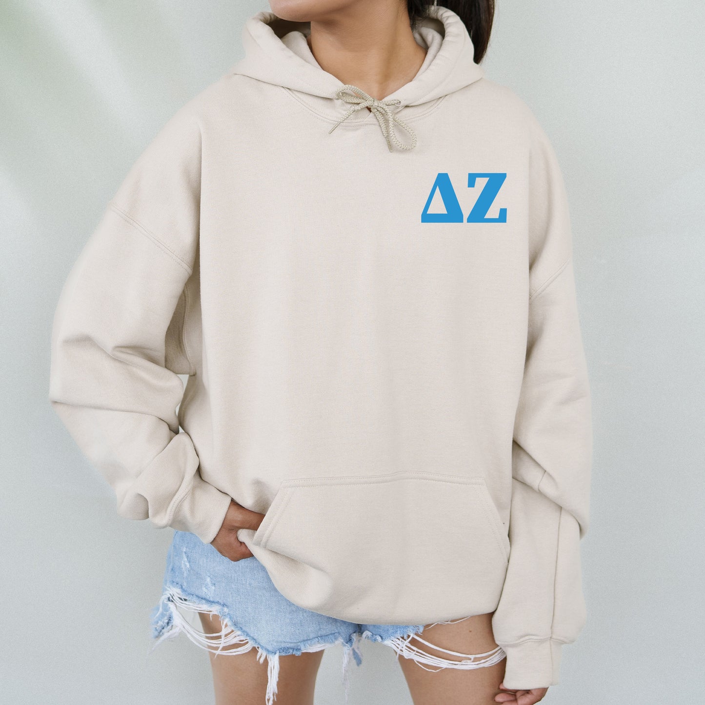 a woman wearing a white hoodie with blue letters on it