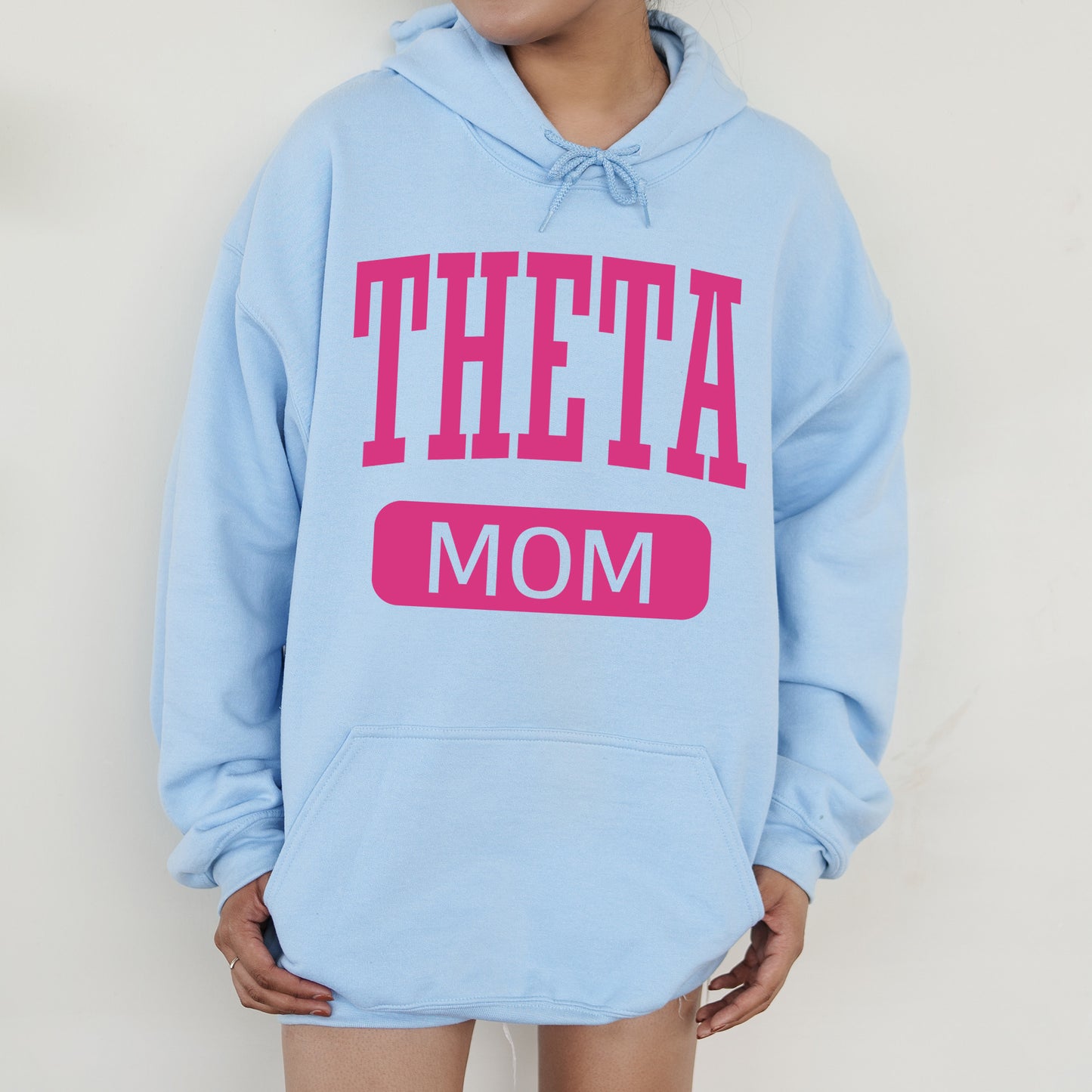 a woman wearing a blue hoodie that says,'theta mom '