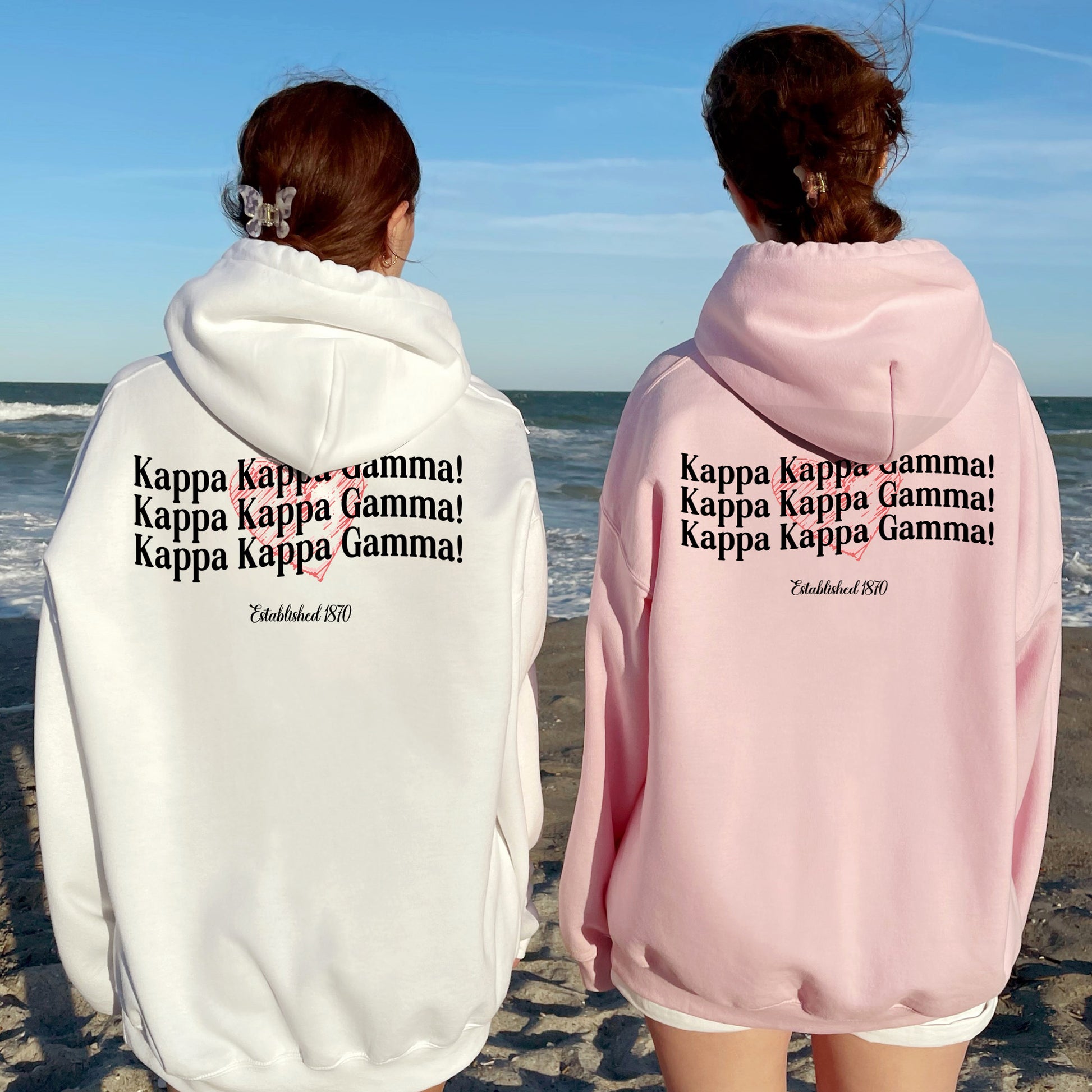 two people standing on a beach with their back to the camera