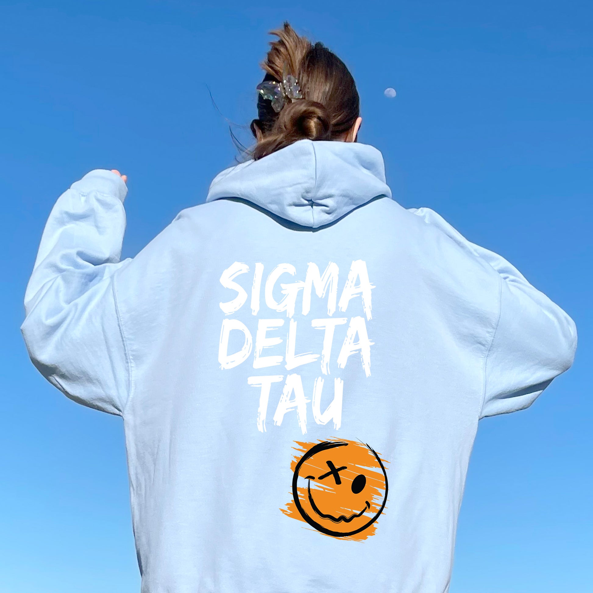 a woman wearing a sweatshirt with a smiley face on it