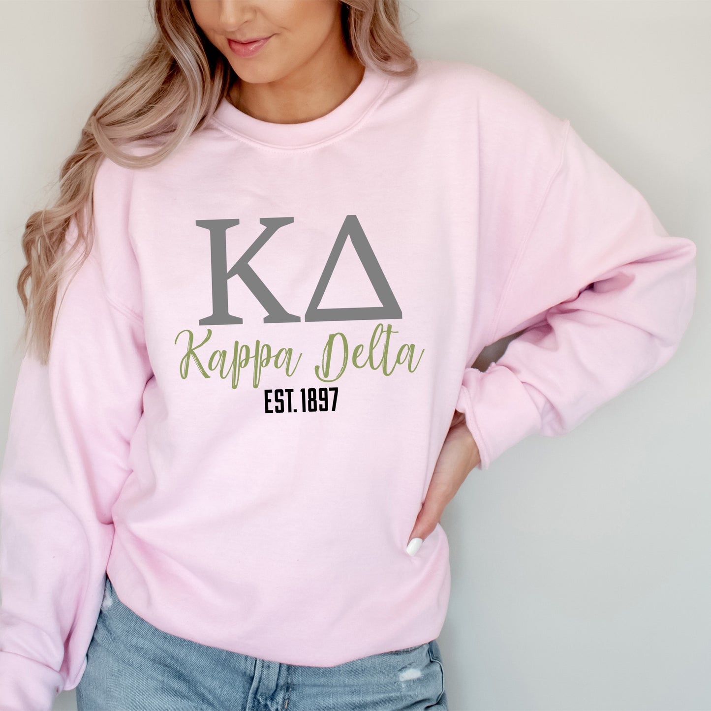 a woman wearing a pink sweatshirt and jeans