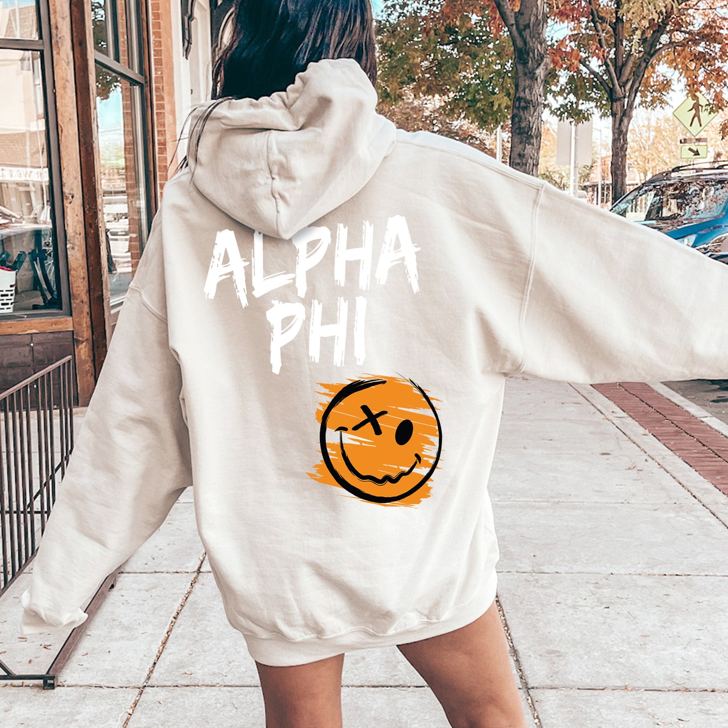 a woman in a white sweatshirt with a smiley face on it